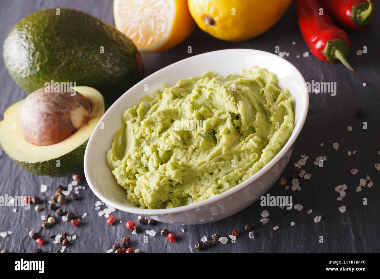 Tradizionale salsa guacamole con ingredienti di close-up sul tavolo. Posizione orizzontale Foto Stock