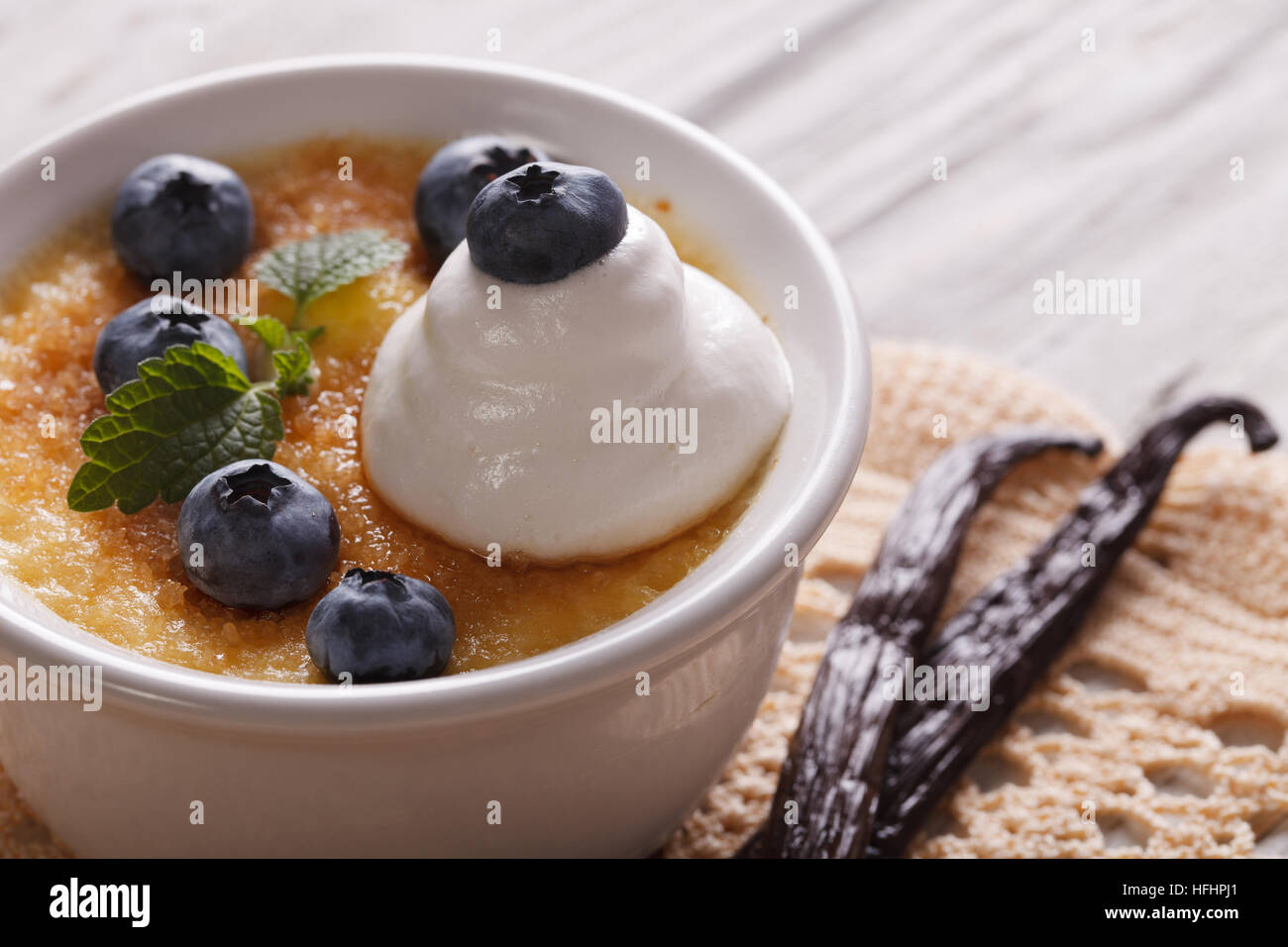 Deliziosi dessert crema brulee con mirtilli vicino sul tavolo orizzontale. Foto Stock