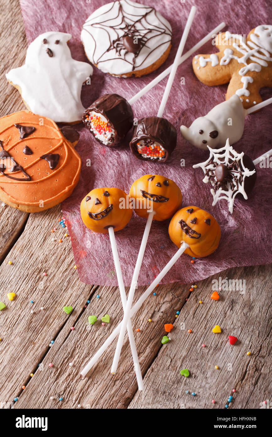 Festosa torta di Halloween pop e gingerbread cookies vicino sul tavolo. verticale vista superiore Foto Stock
