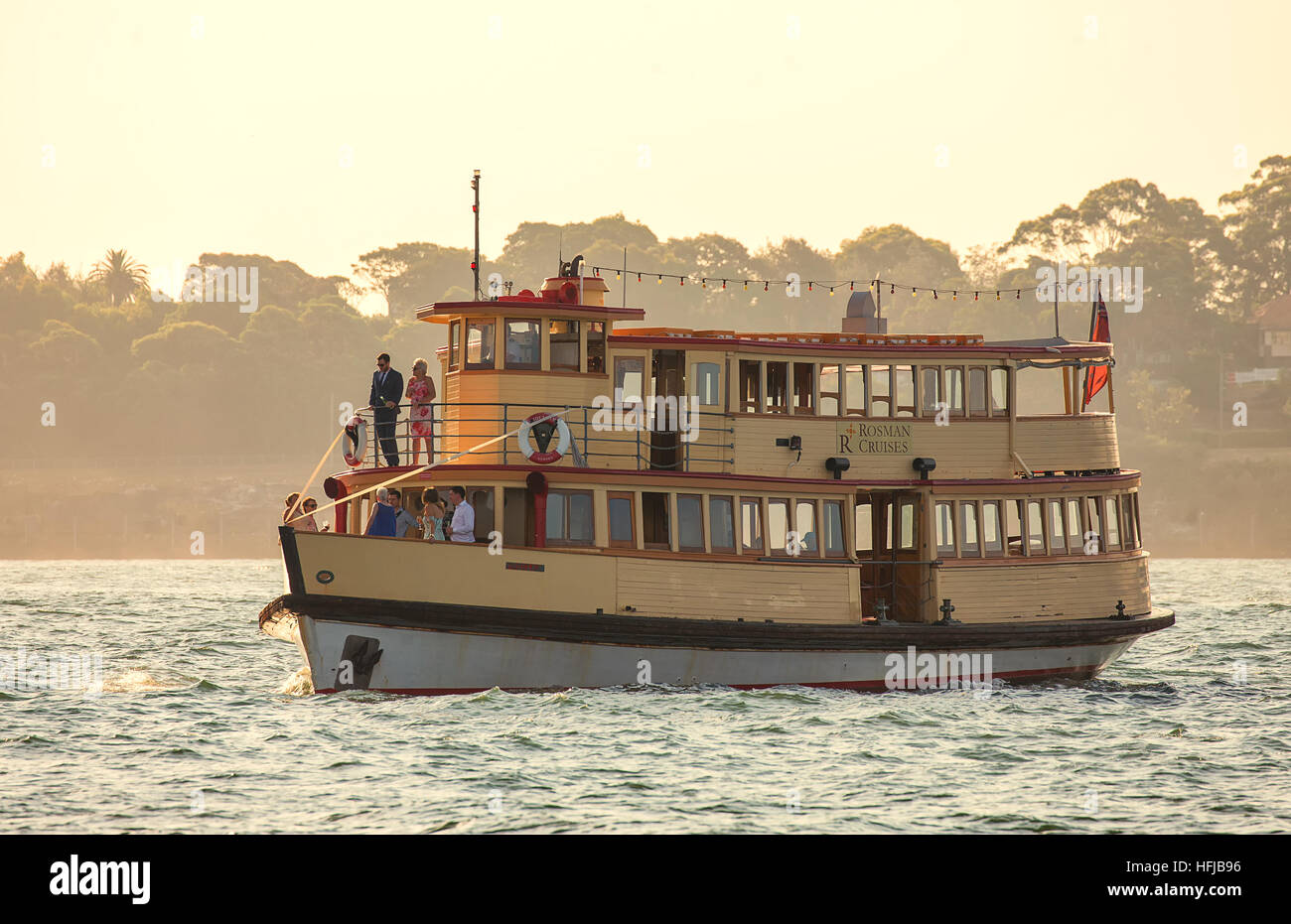 La sposa e lo sposo celebrare con la loro festa di nozze a bordo di un vecchio traghetto in legno sul porto come il sole tramonta. Foto Stock