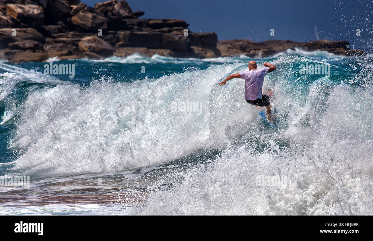 Un surfista salviette fuori su una grande onda alla spiaggia della balena. Surf rimane popolare in Australia nonostante un aumento di fata Foto Stock