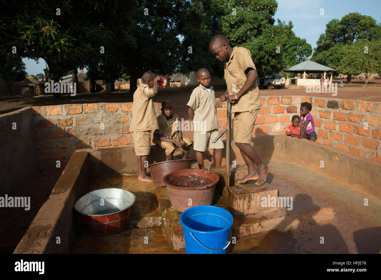 Gbderedou Baranama, Guinea, 2 maggio 2015; questo villaggio e l'area locale saranno allagati dalla diga. Ragazzi scolastici che prelevano l'acqua prima che inizi la scuola. Foto Stock