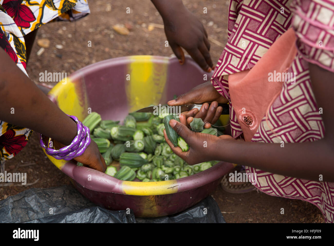 Villaggio Koumban, Guinea, 2° maggio 2015; Fatim Condé,16 ed impegnato a essere sposato, è la vendita di sua madre okra con la sua sorellina che è ancora a scuola. Foto Stock