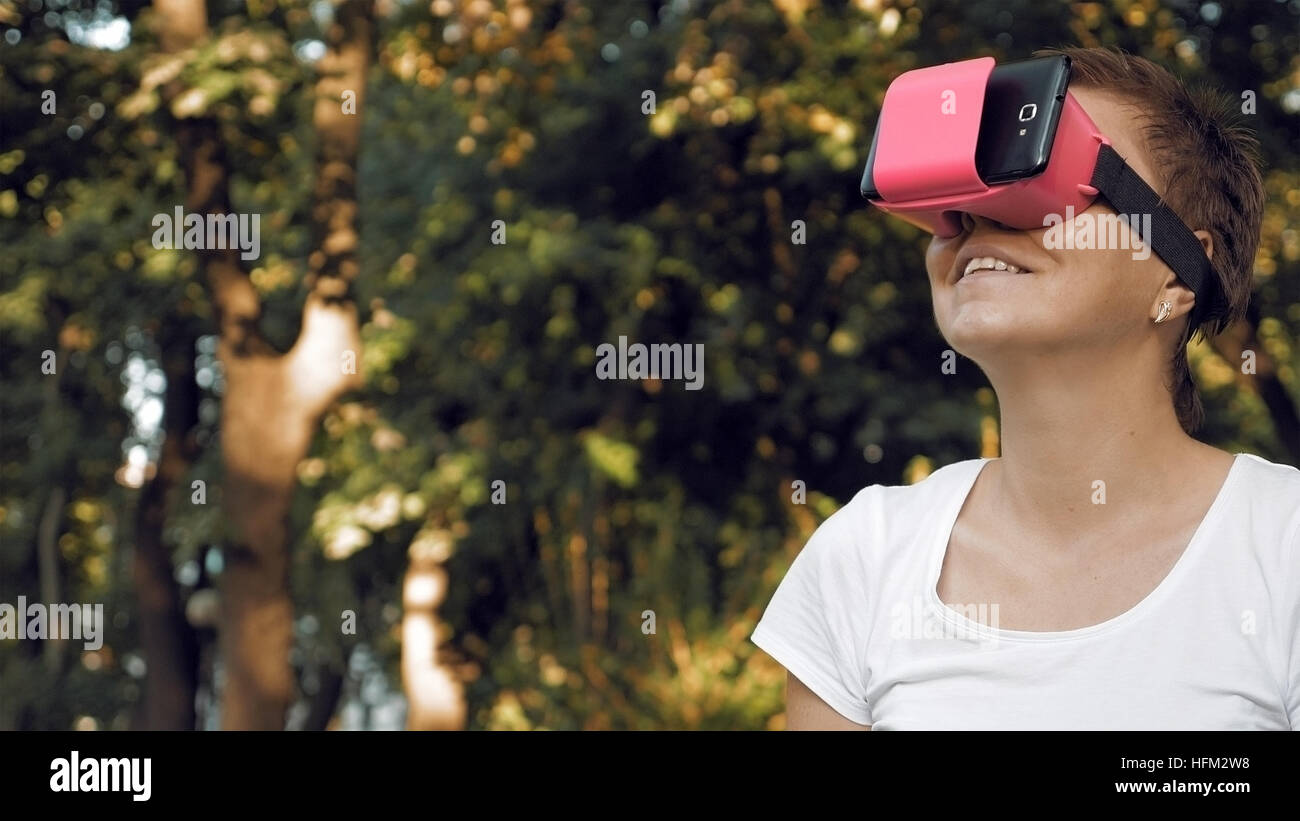 Donna esplora la realtà virtuale utilizzando occhiali VR Foto Stock