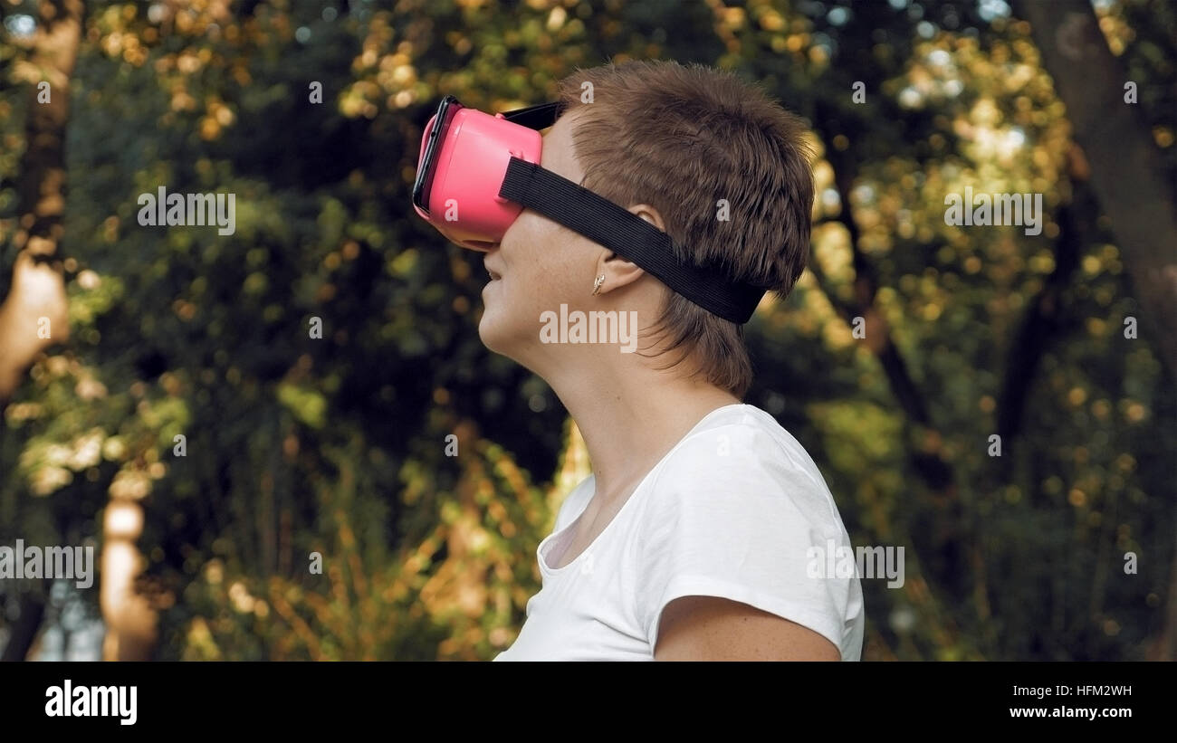 Donna esplora la realtà virtuale utilizzando occhiali VR Foto Stock