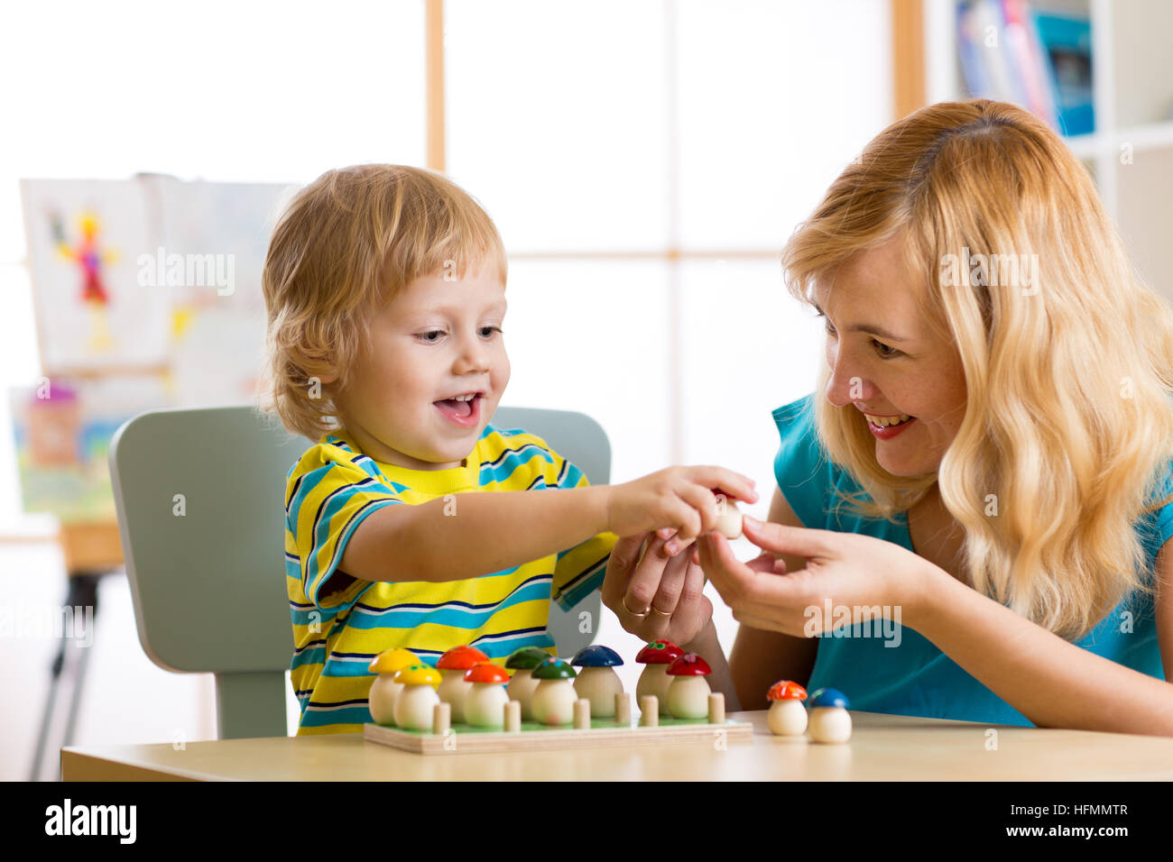 La madre e il bambino impara a colori, dimensioni, conteggio mentre giocando con i giocattoli di sviluppo. Presto il concetto di istruzione. Foto Stock