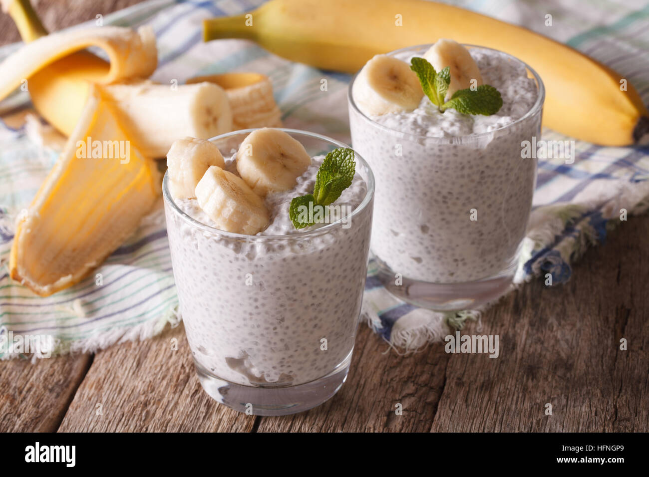 Sana colazione: chia budino di sementi con banana in un bicchiere vicino sul tavolo orizzontale. Foto Stock