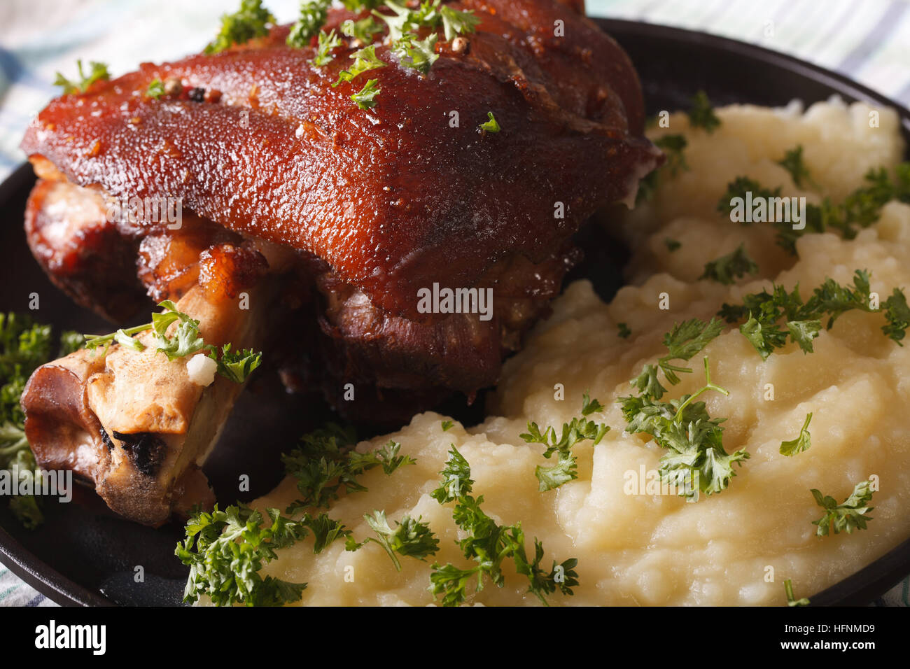 Gustoso lo stinco di maiale e patate schiacciate sulla piastra closeup. orizzontale Foto Stock