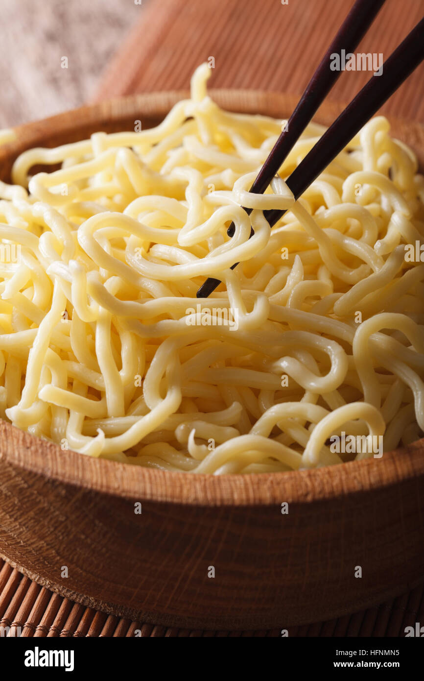 Cibo asiatico: spaghetti ramen macro in una ciotola di legno sul piano verticale. Foto Stock
