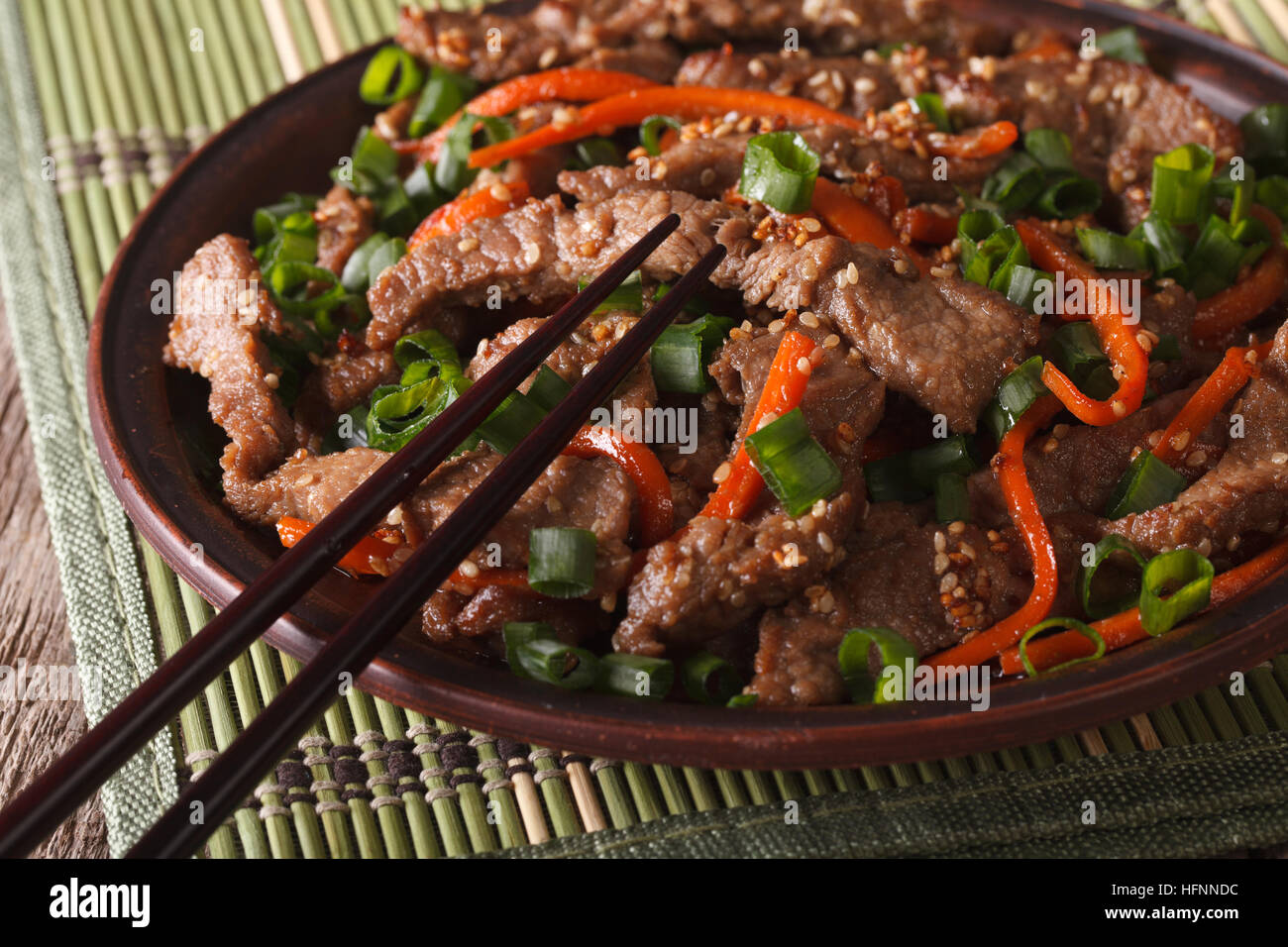 Cibo asiatico: fettine di carne fritti con semi di sesamo e carote closeup. orizzontale Foto Stock