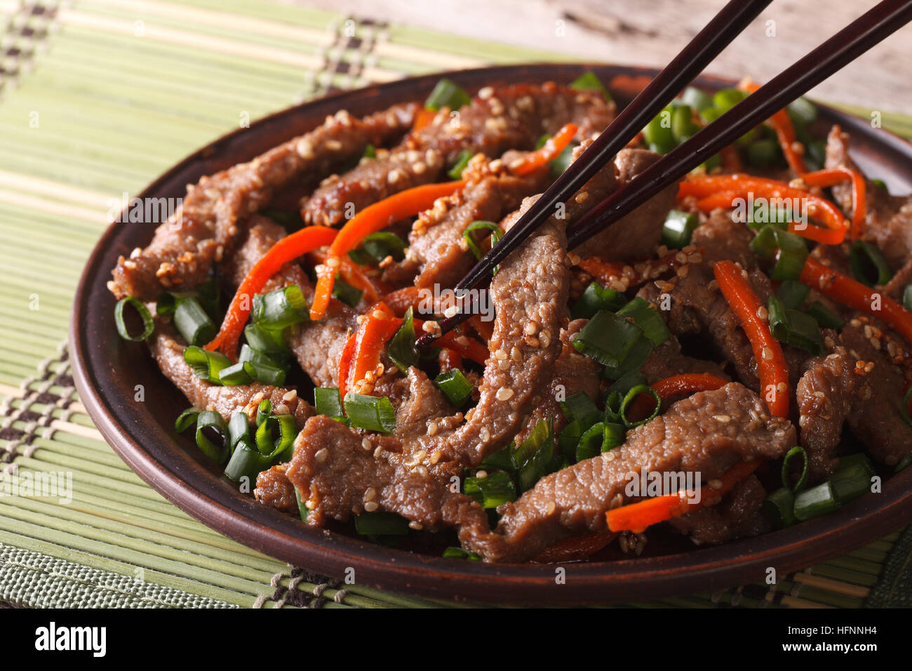 Il tradizionale bulgogi coreano di manzo con la carota e la cipolla sulla piastra closeup. orizzontale Foto Stock