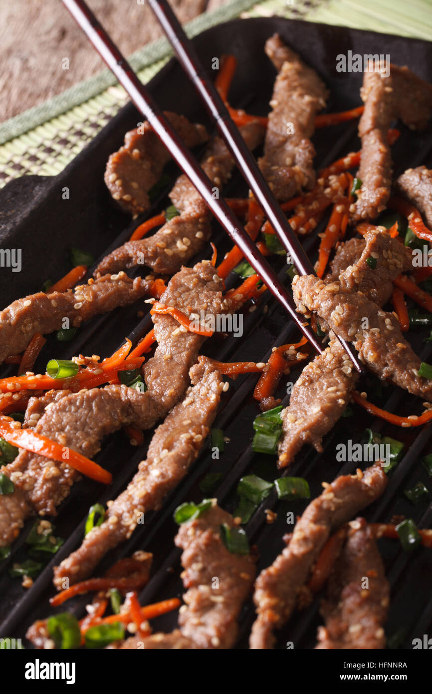 Bulgogi coreano di manzo con la carota e la cipolla sulla griglia macro. In verticale Foto Stock