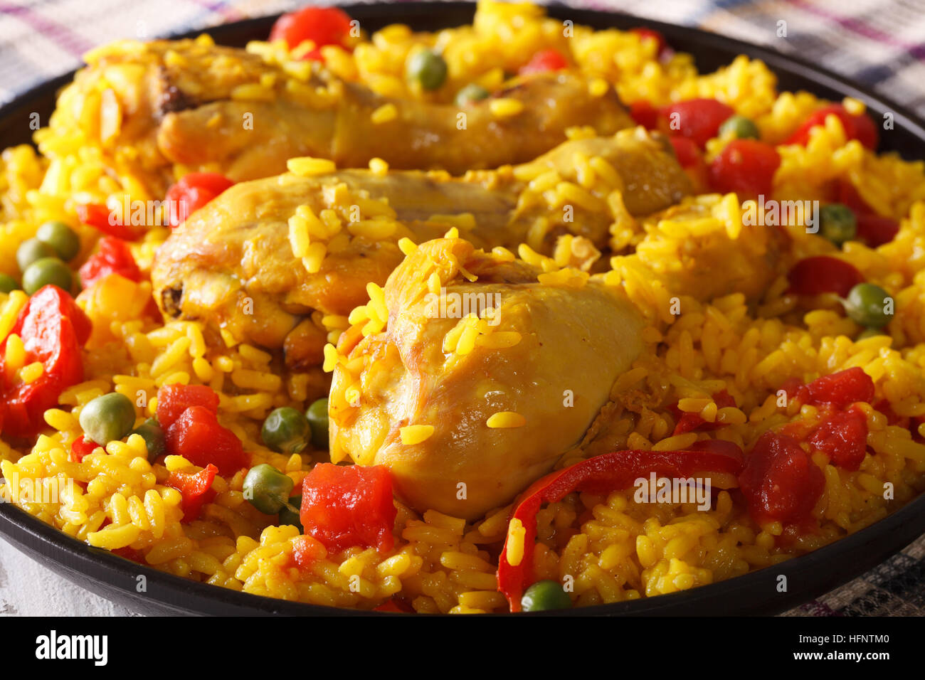 La paella con le cosce di pollo e verdura vicino sul tavolo orizzontale. Foto Stock