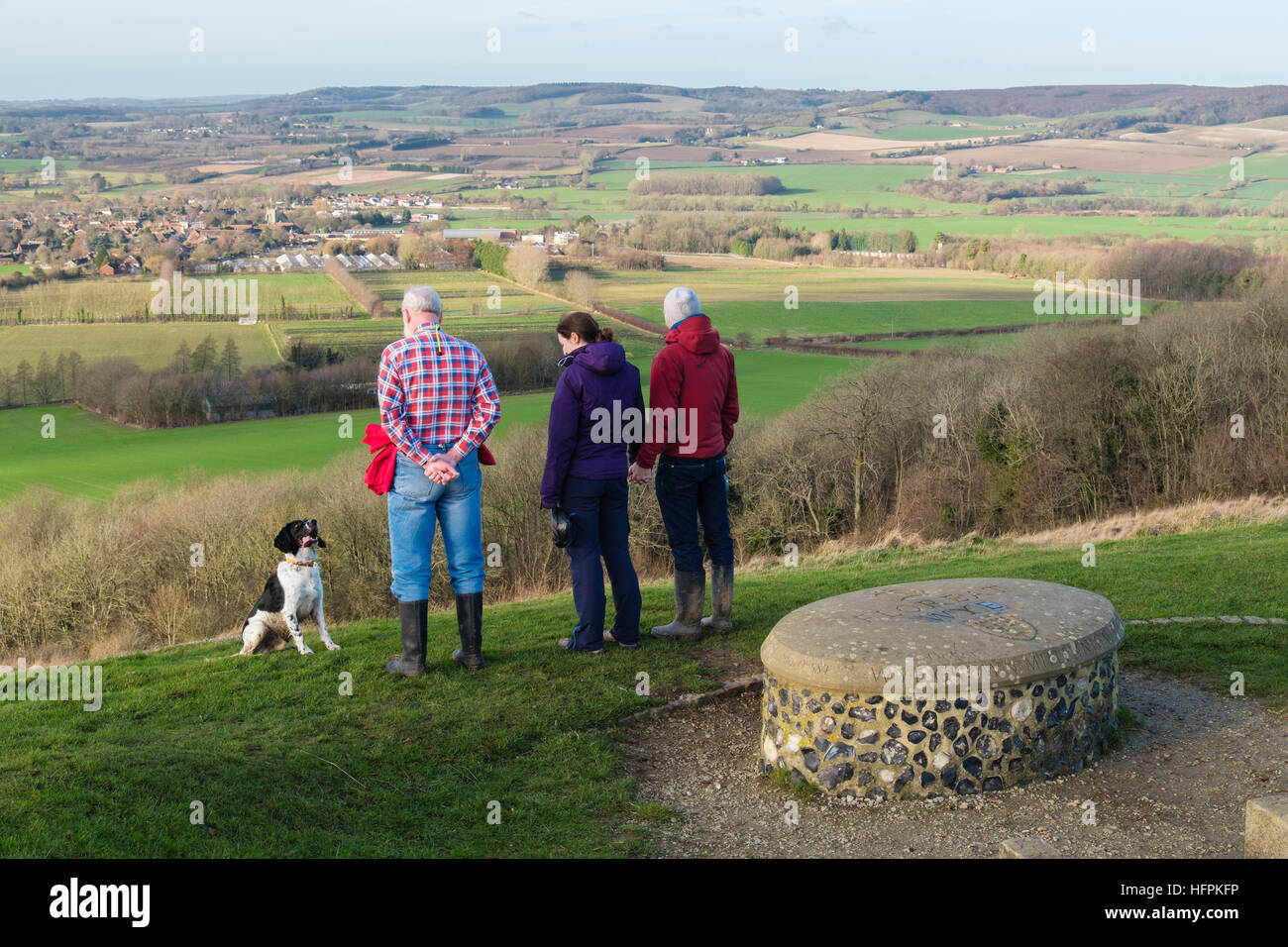 Persone che guardano a vista con un cane dalla corona Wye Millennium stone a Wye Riserva Naturale Nazionale su North Downs. Wye Downs Ashford Kent England Regno Unito Foto Stock