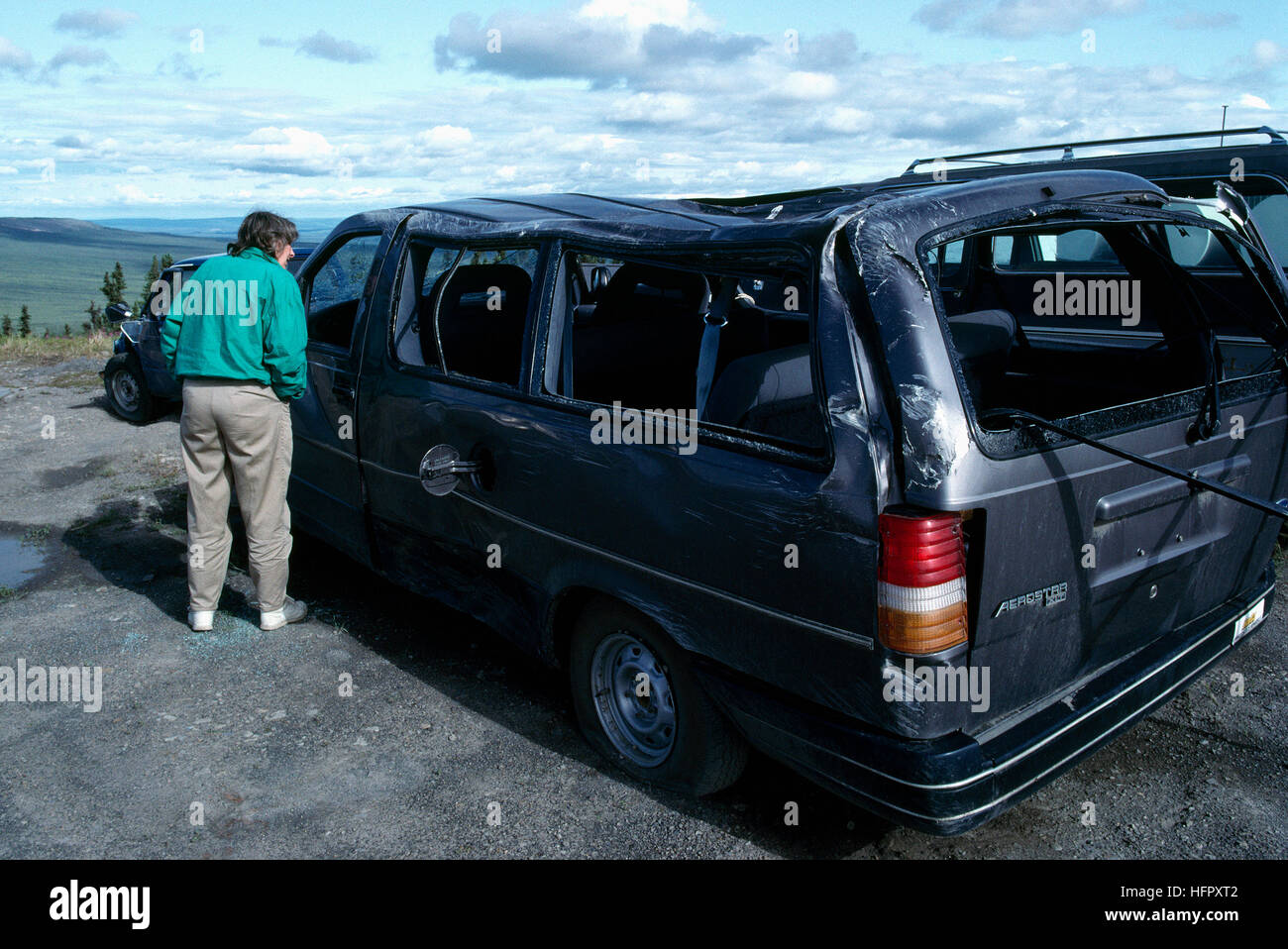 Su strada / autostrada incidente - Donna visualizzazione fracassato auto danneggiato in Auto Crash - vetro rotto, ammaccato tetto danni Foto Stock