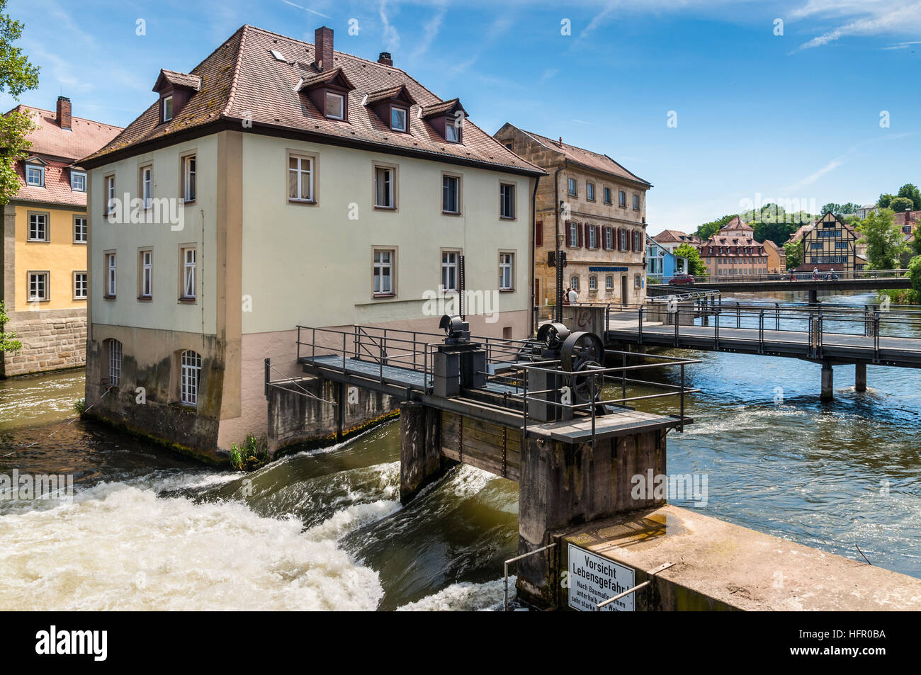 Dighe, ponti, vecchie case sulle isole artificiali e rive del fiume Regnitz Foto Stock