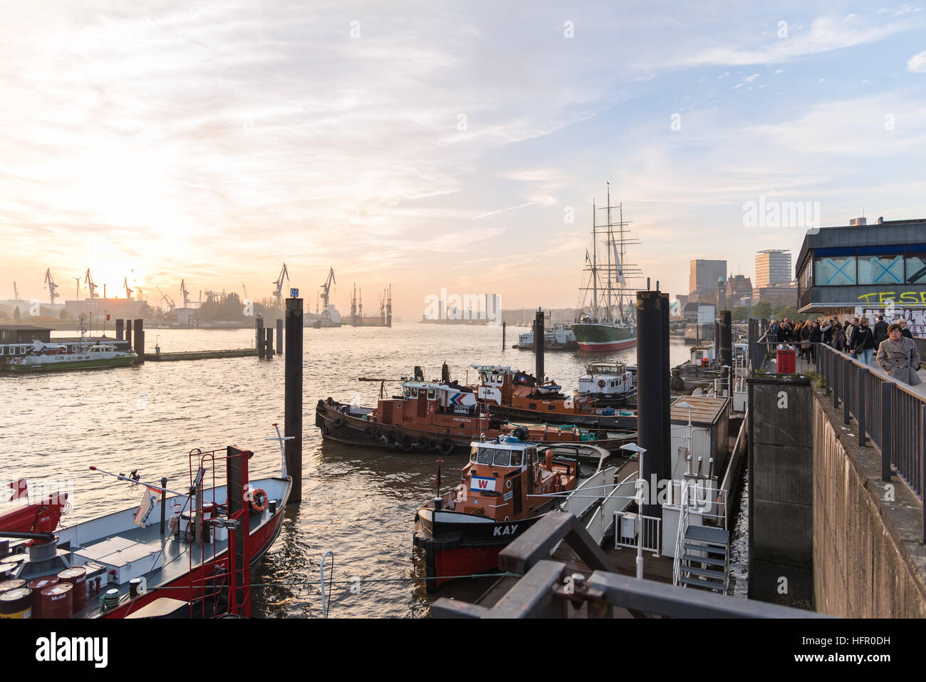 Amburgo, Germania - 01 Novembre 2015: turisti passeggiare lungo il fiume Elba Quay e godetevi la vista panoramica al rosso barche rimorchiatore e dock Foto Stock