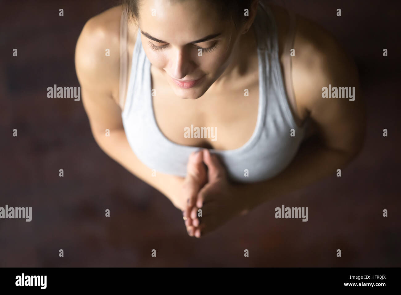 Vista superiore della giovane donna in posa di yoga con Namaste Foto Stock