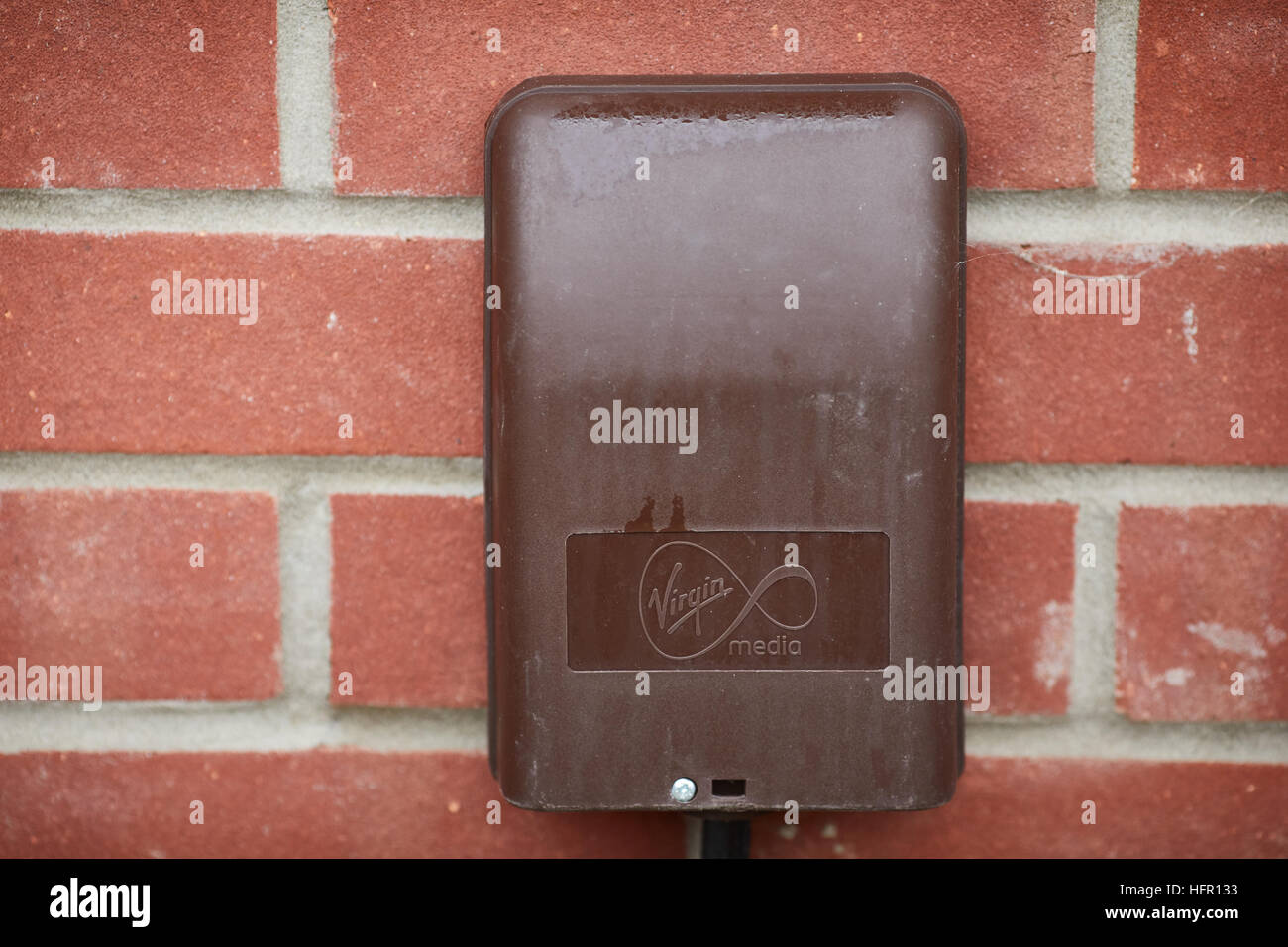 Virgin Media Cavo scatola a banda larga connessione cavo di fibra di collegamento veloce a internet è stato Nynex brown box plastica attaccato al muro di mattoni casa nazionali Foto Stock