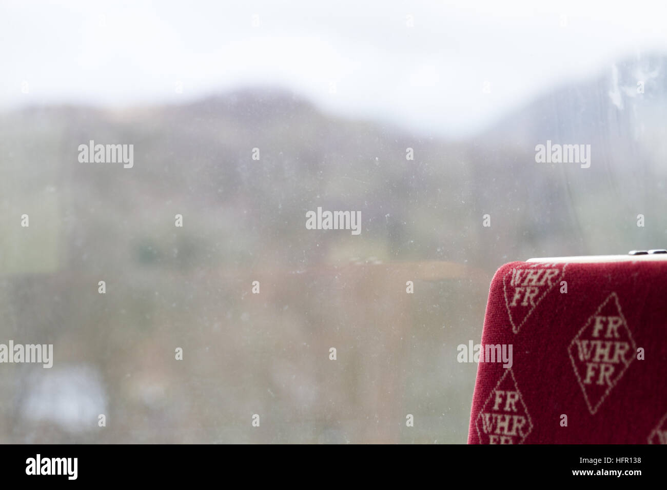 Welsh Highland Railway, WH - Capodanno 2016 - nebbia e colline visto dalla finestra di un treno in contrasto con marchio rosso imbottitura del sedile Foto Stock