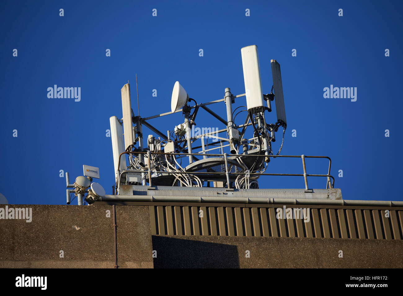 Mobil Telefono sul tetto del montante appartamenti telefono satellitare sito di cella o cella di antenne a torre di apparecchiature di comunicazione posizione alta blue sky trasmettitore/rece Foto Stock