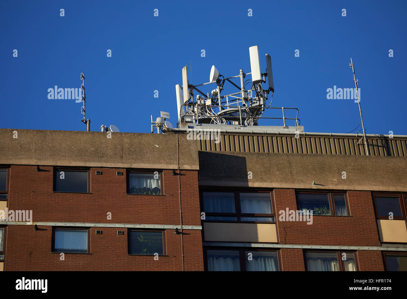 Mobil Telefono sul tetto del montante appartamenti telefono satellitare sito di cella o cella di antenne a torre di apparecchiature di comunicazione posizione alta blue sky trasmettitore/rece Foto Stock