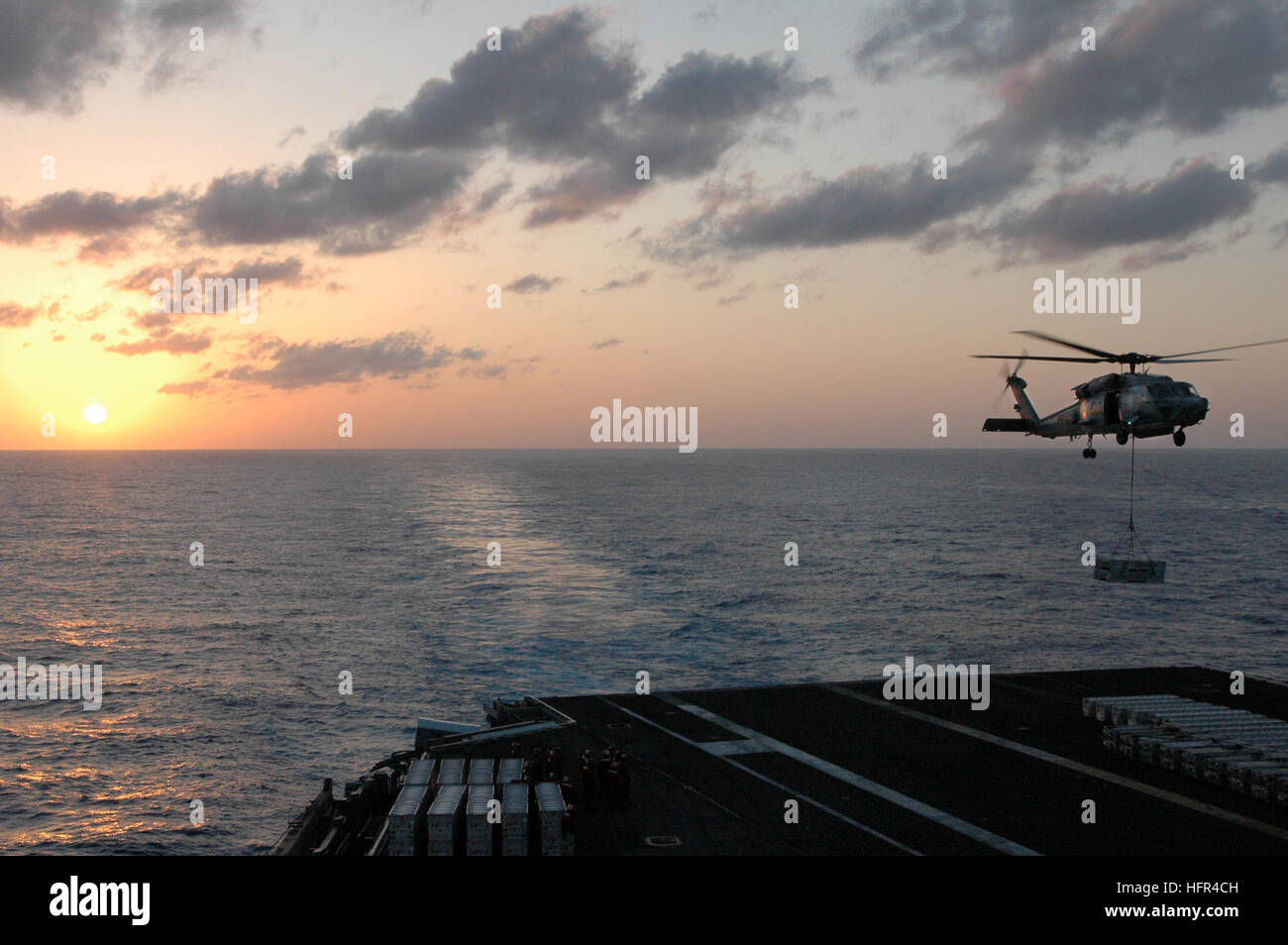 070405-N-1635S-006 sul Mare del Sud della Cina (apr. 5, 2007) - Con il sole che tramonta dietro la portaerei USS Ronald Reagan (CVN 76), un HH-60H Seahawk dal 'Cavalieri Neri' di elicottero Anti-Submarine Squadron (HS) 4 sale al di sopra del ponte di volo durante un'ordnance offload di evoluzione con i militari Sealift Command (MSC) munizioni nave USNS selce (T-AE 32). Aviation Ordnancemen scaricata oltre 126 barattoli di munizioni durante l'evoluzione. Il Ronald Reagan Carrier Strike gruppo è in corso su una distribuzione di pompaggio a sostegno degli Stati Uniti per le operazioni militari nel Pacifico occidentale. Ufficiale DEGLI STATI UNITI Nav Foto Stock