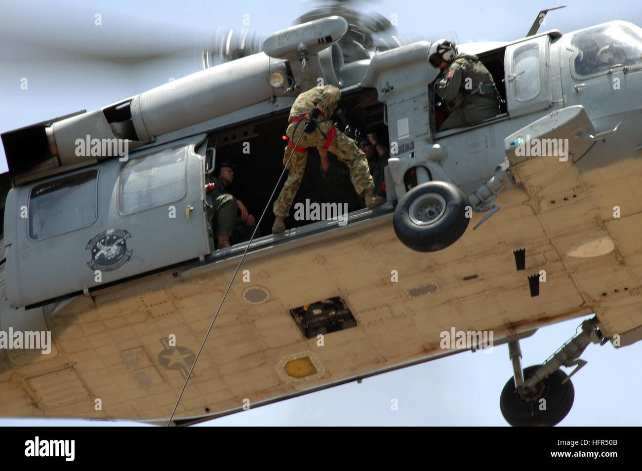 060419-N-7293M-059 Santa Rita, Guam (19 aprile 2006) - Un'eliminazione degli ordigni esplosivi tecnico assegnato alla Royal Australian Navy si prepara a rappel da un MH-60S Seahawk elicottero assegnato al mare in elicottero squadrone di combattimento due cinque (HSC-25), durante un elicottero corda tecnica di sospensione (HRST) esercizio tenuto su Polaris Point. La Australian tecnici sono a Guam per partecipare annualmente una multi-nazionale EOD esercizio noto come ÒTricrab 2006.Ó Tricrab riunisce l'eliminazione degli ordigni esplosivi di unità da parte degli Stati Uniti, in Australia e a Singapore. Stati Uniti Navy foto dal fotografo Foto Stock