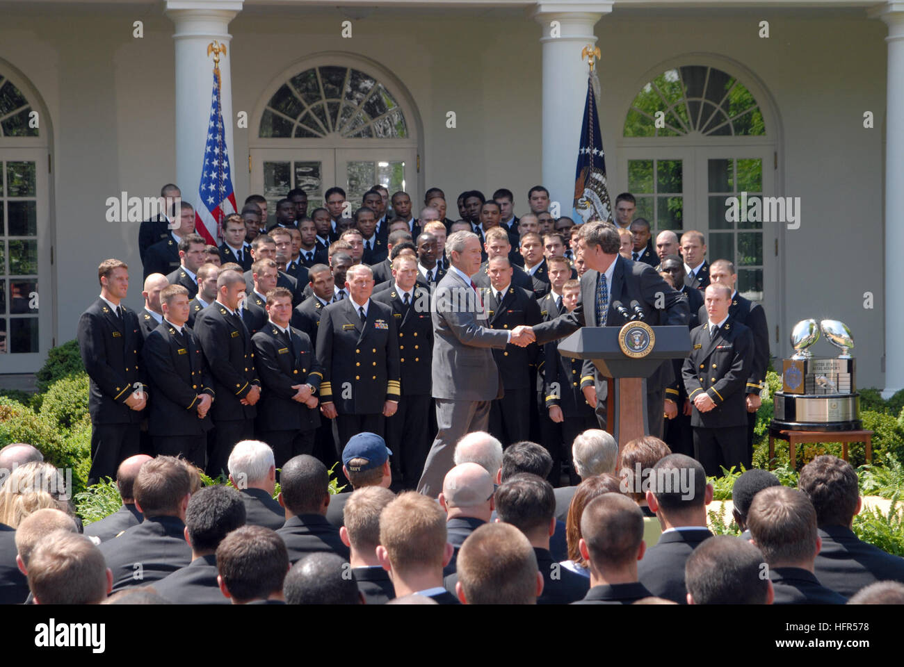 060425-N-9909C-007 W. Bush scuote le mani con la Marina Militare allenatore di calcio Paul Johnson durante la presentazione ufficiale del Comandante in Capo trofeo per la US Naval Academy football team alla Casa Bianca il Giardino di Rose. Il comandante in ChiefÕs trophy è assegnato al servizio con la migliore inter-service record di calcio. Questo è il terzo anno consecutivo Marina ha vinto il trofeo. Stati Uniti Foto di Marina dalla Cmdr. Jane Campbell (rilasciato) Navy US 060425-N-9909C-007 Presidente George W Bush scuote le mani con la Marina Militare allenatore di calcio Paul Johnson durante la presentazione ufficiale del Comandante in Capo Tr Foto Stock