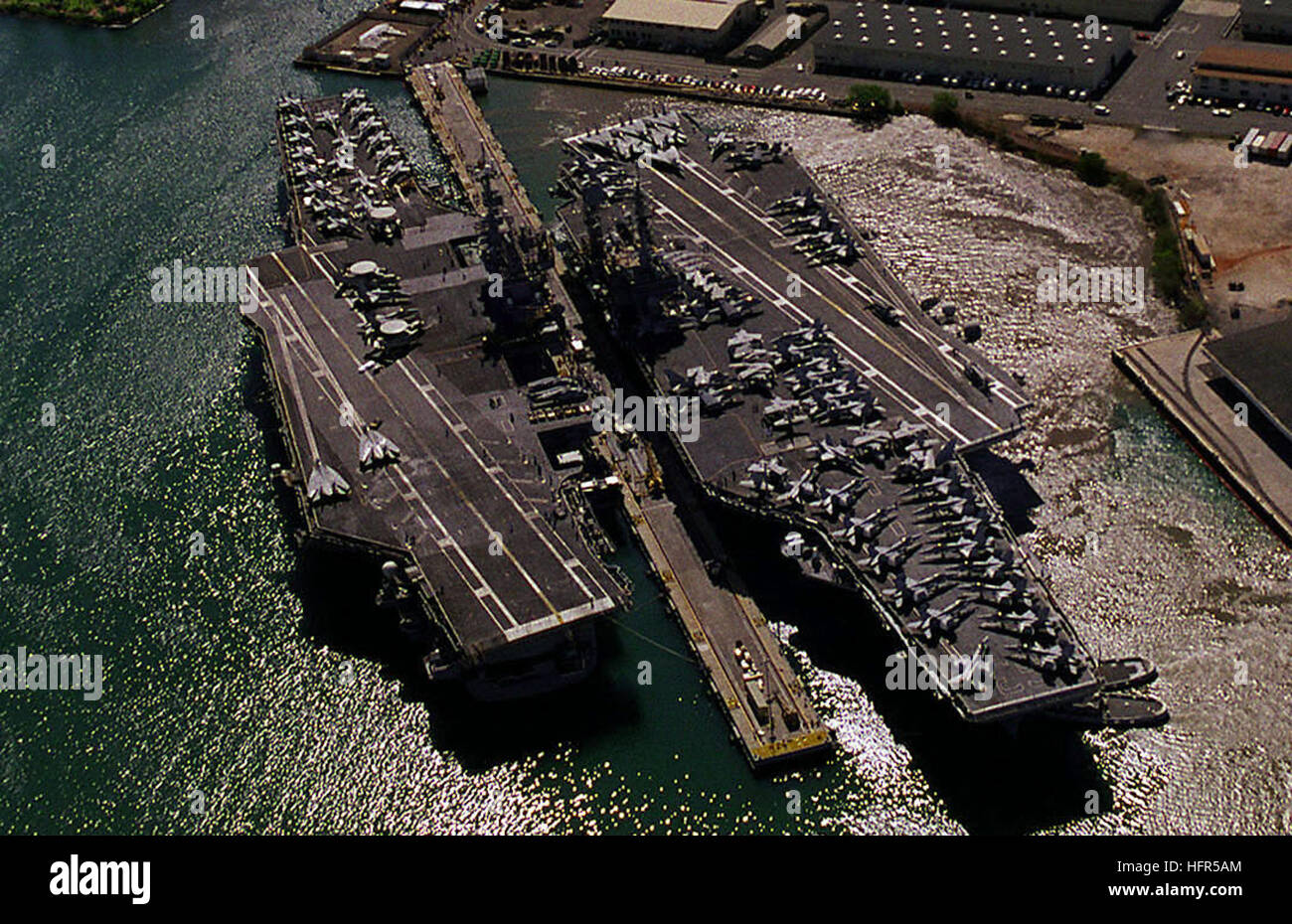 Una veduta aerea della portaerei USS INDIPENDENZA (CV 62), a sinistra e a USS Kitty Hawk (CV 63), destra, legato allo stesso dock in preparazione per la variazione di carica durante l'esercizio RIMPAC '98. USS Indipendenza (CV-62) e USS Kitty Hawk (CV-63) presso Pearl Harbor raccolto Foto Stock