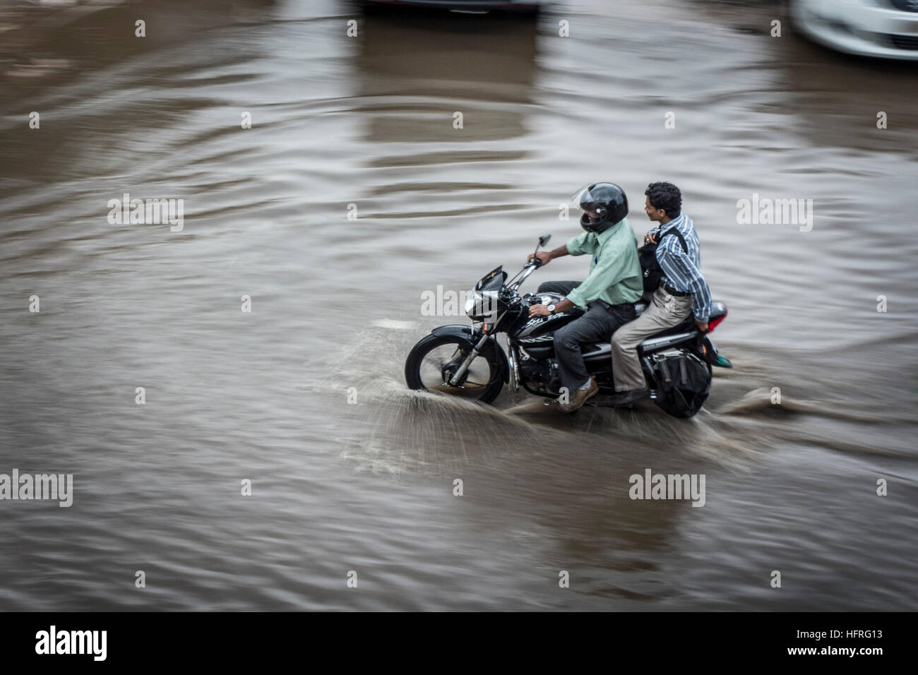Due persone su una moto guadato allagato strade. Jaipur, India. Foto Stock