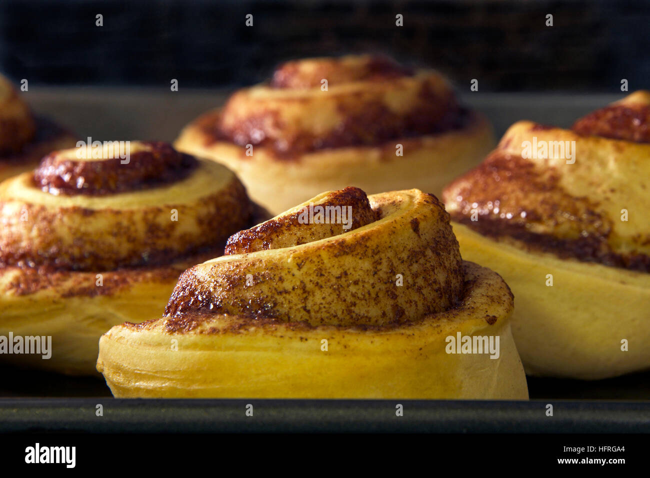 Panini alla cannella cottura in un forno a convezione, quasi fatto Foto Stock