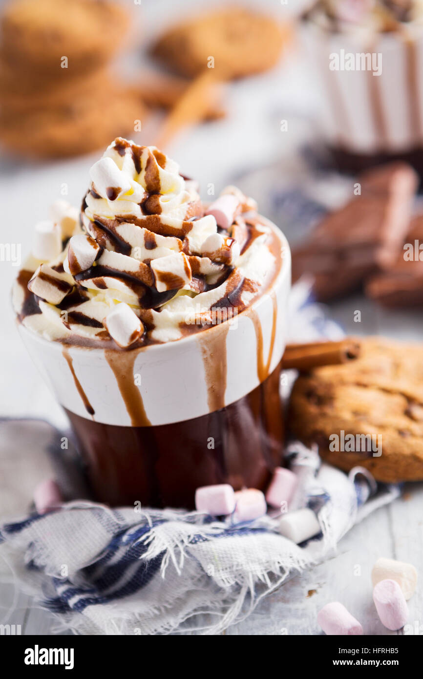 Un confuso con la tazza di cioccolata calda, panna montata, marshmallows e biscotti al cioccolato. Foto Stock Un confuso con la tazza di cioccolata calda, panna montata, marshmallows e biscotti al cioccolato. Foto Stock