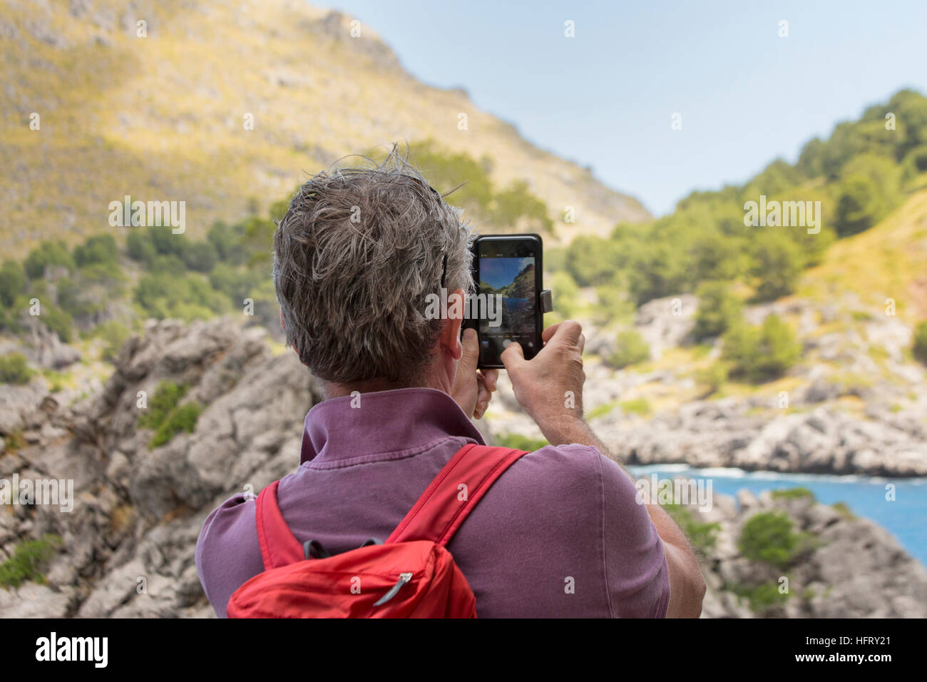 Uomo che fa la foto del paesaggio con telefono cellulare Foto Stock