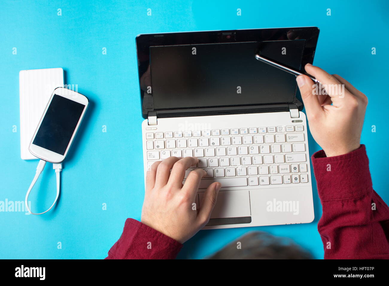 Uomo che utilizza un bianco lap top sul tavolo blu Foto Stock