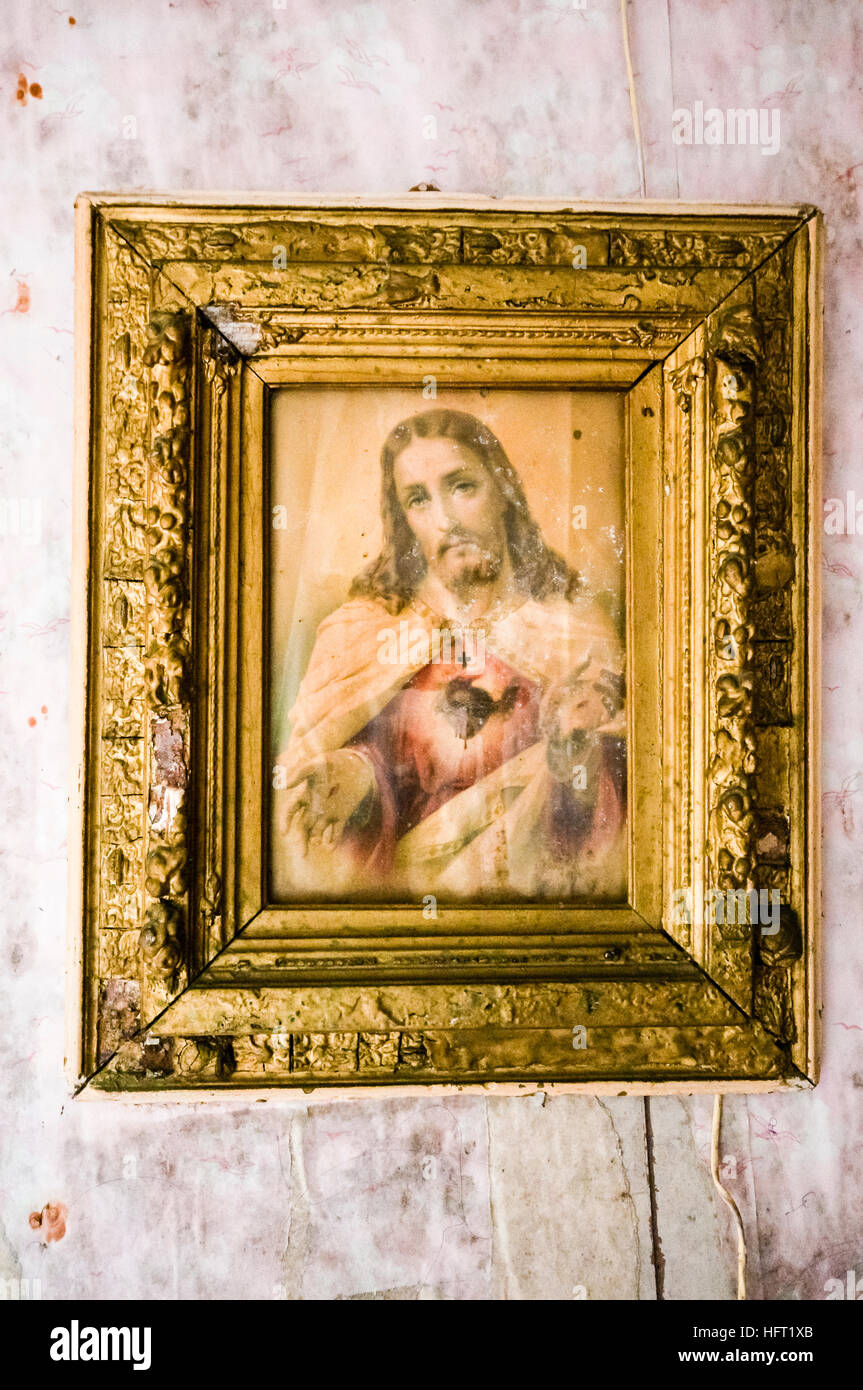 Molto vecchio Sacro Cuore immagine di Gesù Cristo si blocca su un muro sporco. Foto Stock
