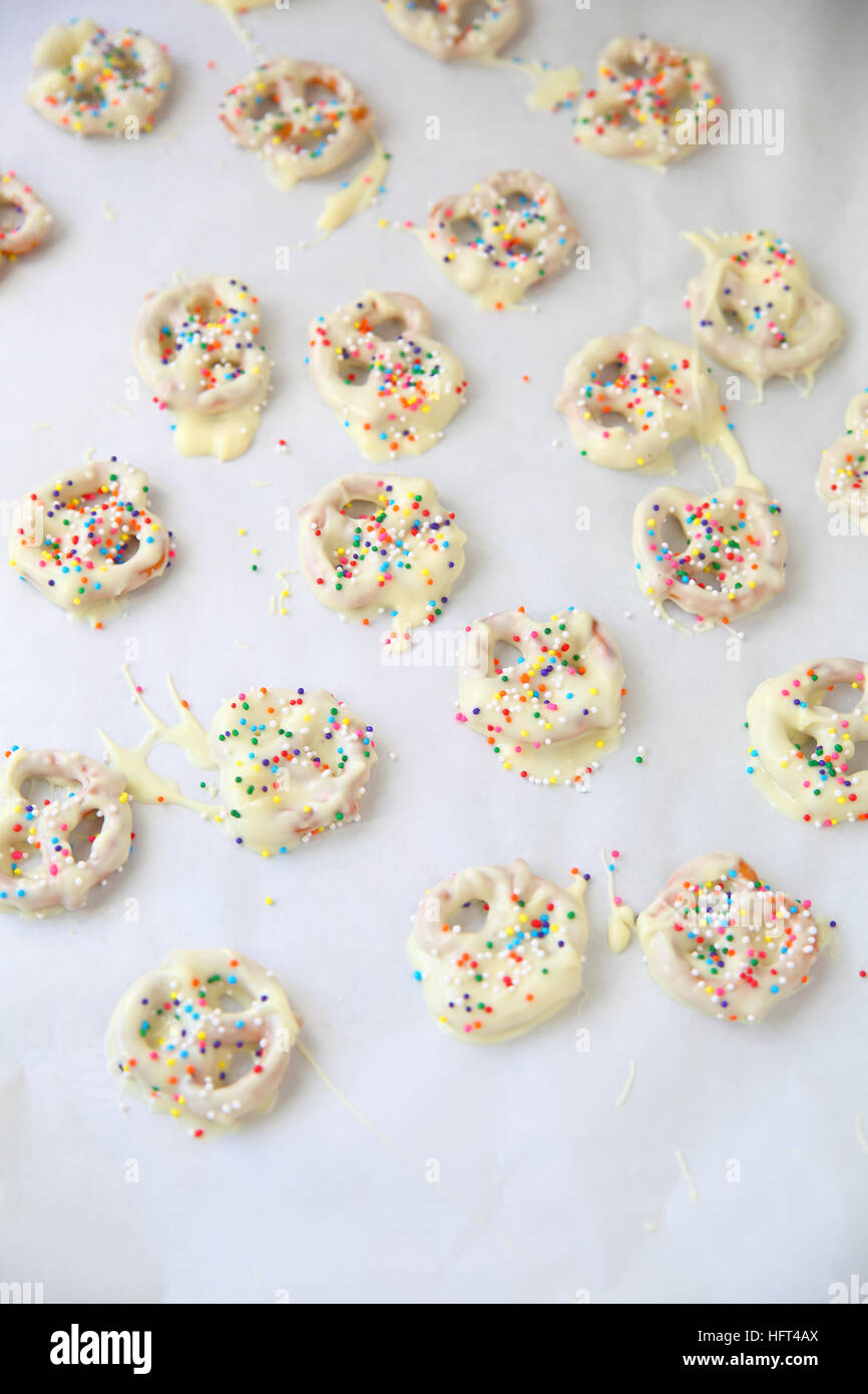 In casa il cioccolato bianco-coperto pretzel con colorati spruzza e spazio di copia Foto Stock