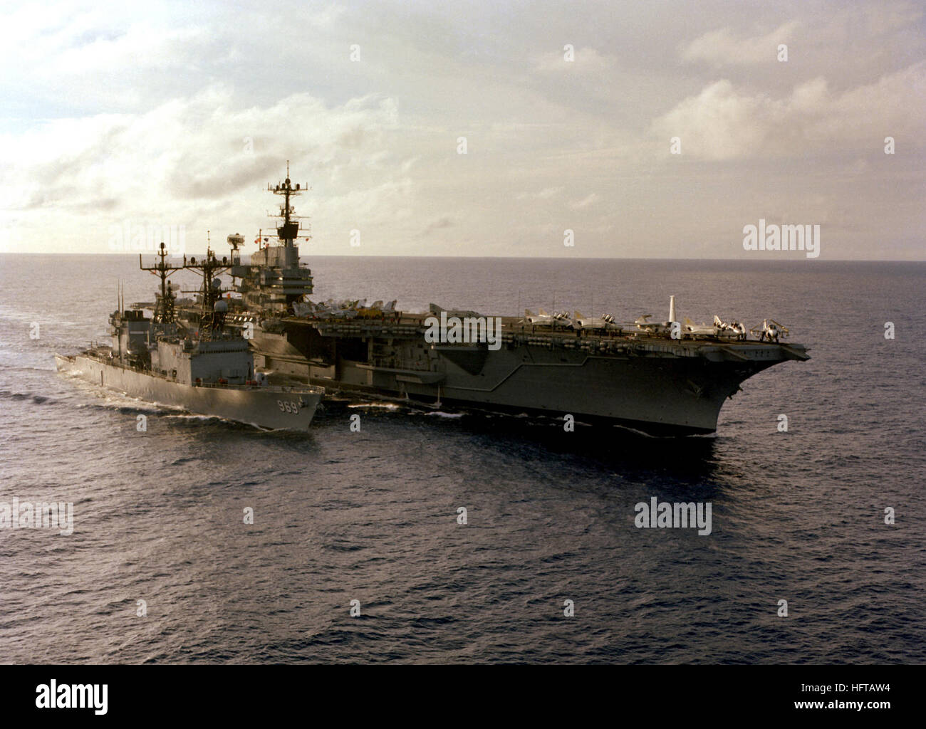 Una vista di tribordo della portaerei USS INDIPENDENZA (CV-62) attualmente in corso con il cacciatorpediniere USS PETERSON (DD-969) accanto a. USS Indipendenza (CV-62) e USS Peterson (DD-969) nel 1979 Foto Stock
