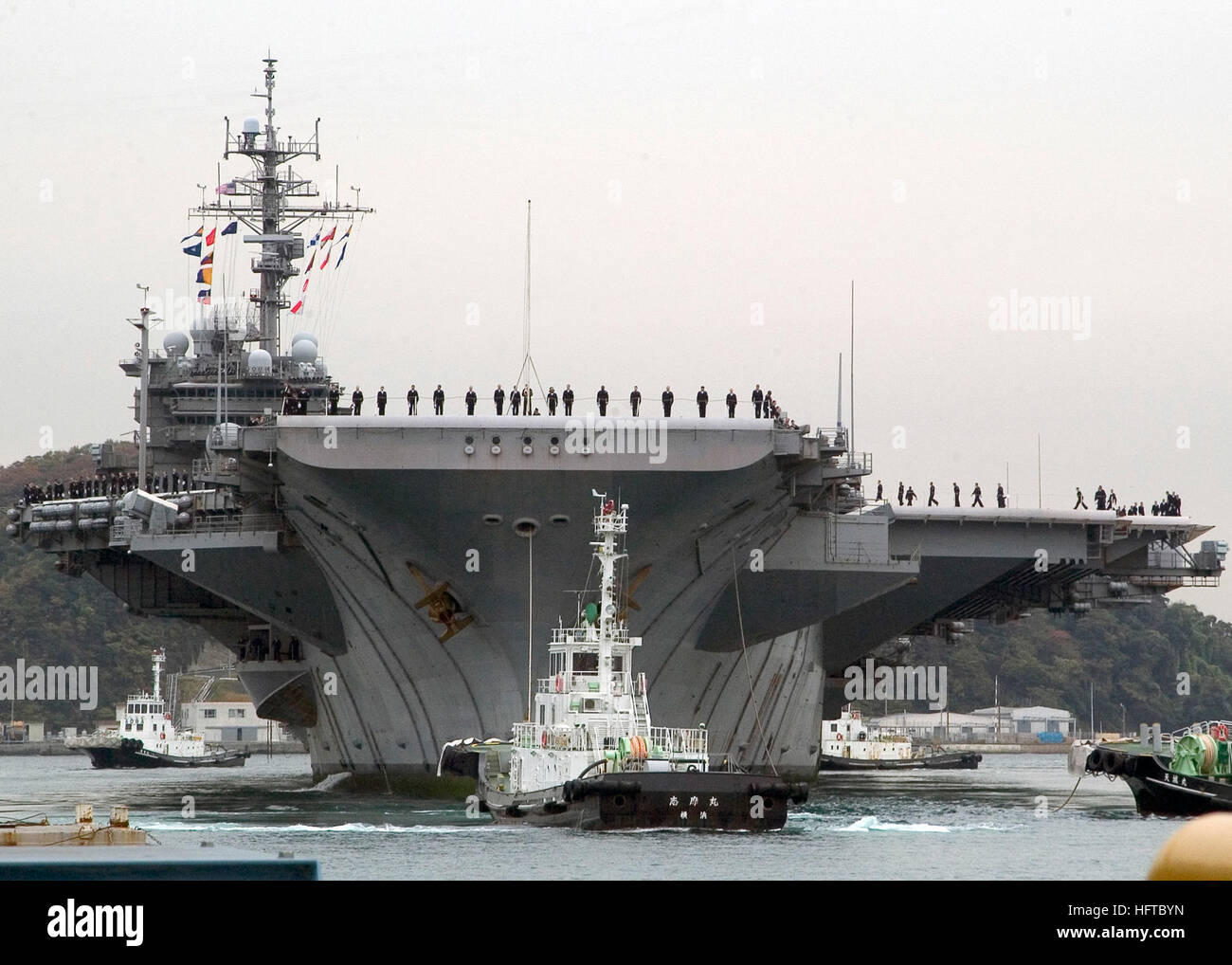 071127-N-0483B-003 Yokosuka, Giappone (nov. 27, 2007) i marinai a bordo della USS Kitty Hawk (CV 63) uomo le rotaie come la nave arriva in porto. Kitty Hawk, il mondo solo permanentemente in avanti schierate portaerei, restituito dopo il completamento di una caduta programmata la distribuzione e la partecipazione in ANNUALEX, la componente marittima degli Stati Uniti-Giappone esercizio appassionato di spada 08. L'esercizio è stato progettato per aumentare l'interoperabilità tra gli Stati Uniti e la JMSDF e migliorare la loro capacità di essere efficacemente al e reciprocamente rispondere ad una crisi regionale situazione. Stati Uniti Navy foto di comunicazione di massa Se lo specialista Foto Stock