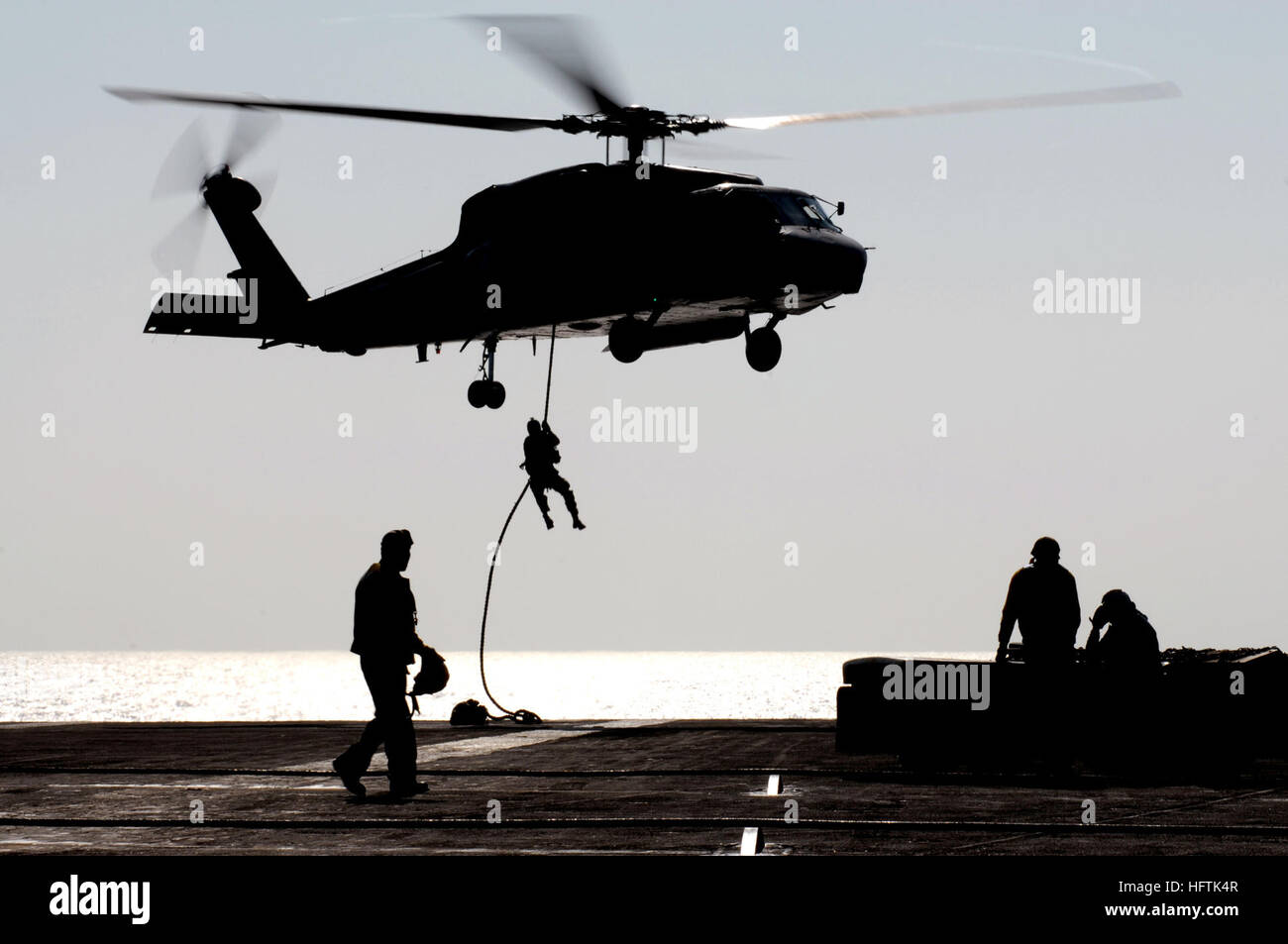 070403-N-7130B-194 sul Mare del Sud della Cina (3 aprile 2007) - Durante un'aria di dimostrazione di potenza per l'equipaggio della USS Ronald Reagan (CVN 76), una SH-60F Seahawk, assegnato al "cavalieri neri" di elicottero Anti-Submarine Squadron (HS) 4, posiziona il puntatore del mouse mentre un membro dell'eliminazione degli ordigni esplosivi unità mobile (EODMU) 11, di distacco 15, fast-corde per il ponte di volo. La potenza aerea dimostrazione è stata eseguita da Carrier aria Wing (CVW) 14 e in primo piano la partecipazione di ciascuna delle otto squadroni assegnati a CVW-14. Ronald Reagan Carrier Strike gruppo è in corso a sostegno delle operazioni nel Pacifico occidentale. Brevetto statunitense n. Foto Stock