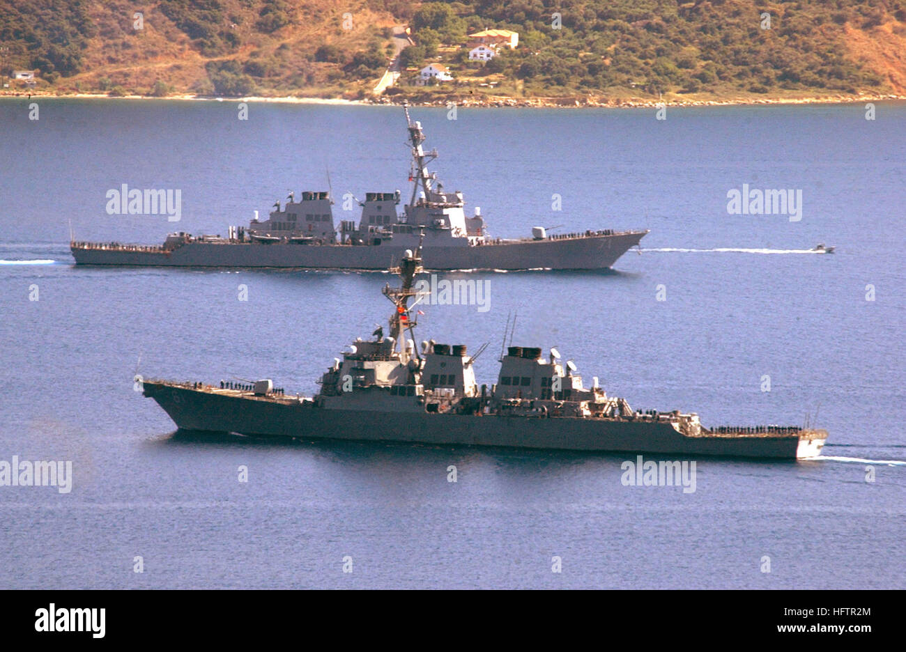 040625-N-0780F-070 Souda Bay, Creta, Grecia (25 giugno 2004) - il missile destroyer USS Ross (DDG 71), top, crociere nel porto di Souda per una breve visita di porta come il missile destroyer USS Ramage (DDG 61) si diparte a seguito di un breve soggiorno nel Mediterraneo orientale porta. Entrambi Arleigh Burk-cacciatorpediniere della classe sono assegnati a Destroyer Squadron due otto (DESRON-28) e la casa di porting a Norfolk, Virginia entrambe le navi sono attualmente nel Mar Mediterraneo a condurre una regolare distribuzione pianificata. Stati Uniti Navy foto di Paul Farley (rilasciato) USS Ramage DDG-61 e USS Ross DDG-71 pass a Souda Bay Foto Stock
