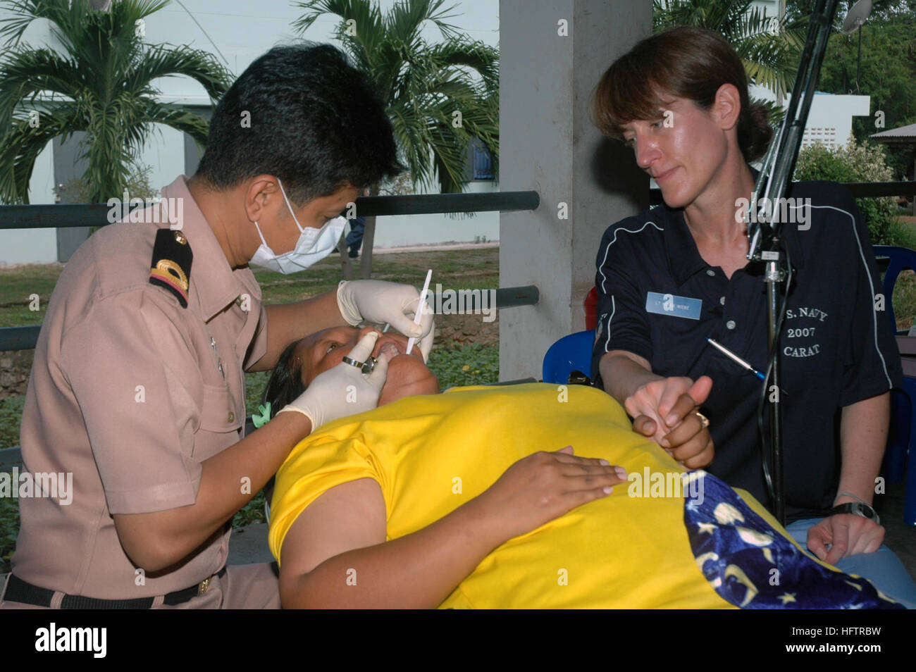 070619-N-7783B-001 DIVIETO SAMSAN, Thailandia (19 giugno 2007) - Un Royal Thai Army dentista dà un colpo di intorpidimento di un cittadino locale, mentre Lt. Karen Wiebe, assegnato alla salute operativa Unità di supporto distacco Lima Grandi Laghi, comfort di lei. Entrambi i dentisti sono state lavorando insieme durante un dentista di azione civile progetto (DENCAP) in un villaggio locale durante l'esercizio la cooperazione a galla la prontezza e la formazione (Carati) 2007. Carato è prevista una serie di accordi bilaterali di formazione militare esercizi con diversi Southeast Asia nazioni progettate per migliorare l'interoperabilità dei rispettivi servizi marittimi. Stati Uniti Navy pho Foto Stock