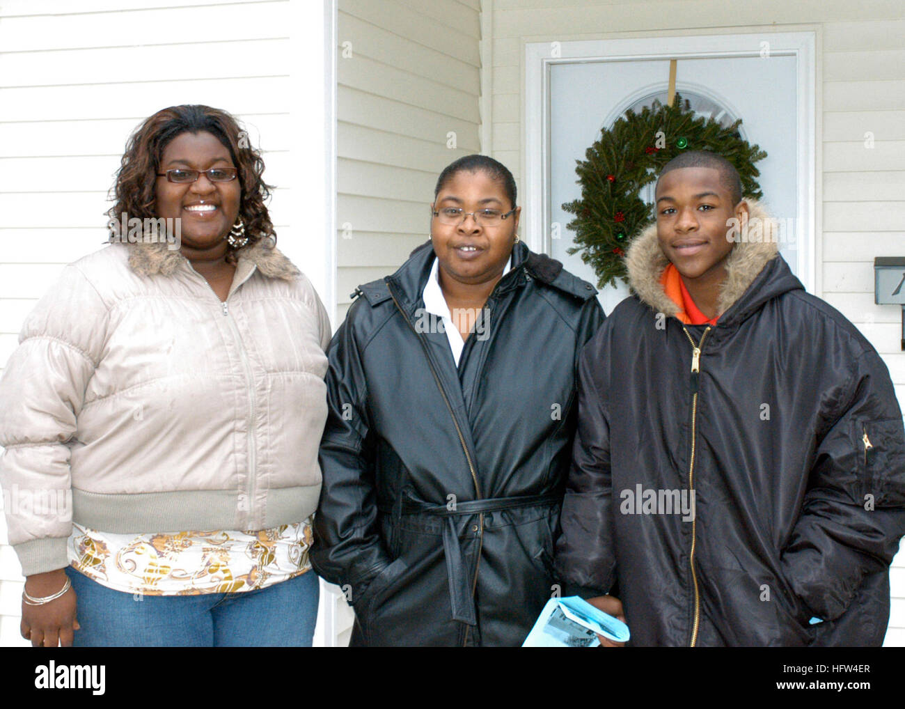 071215-N-4680O-001 PORTSMOUTH Va. (dec. n. 15, 2007) Nuovi proprietari Lateshia, Sylvia, Tyrell e Walton stand davanti alla loro nuova casa costruita da Habitat per l'umanità. I volontari della multi-purpose Amphibious Assault nave USS Bataan (LHD 5) volontariamente il loro tempo per aiutare a Habitat for Humanity costruire due case che sono stati dedicati che giorno. Stati Uniti Navy fotografia di comunicazione di massa Specialist Seaman Shamus OÕNeill (rilasciato) Navy US 071215-N-4680O-001 nuovi proprietari Lateshia, Sylvia, Tyrell e Walton stand davanti alla loro nuova casa costruita da Habitat for Humanity Foto Stock