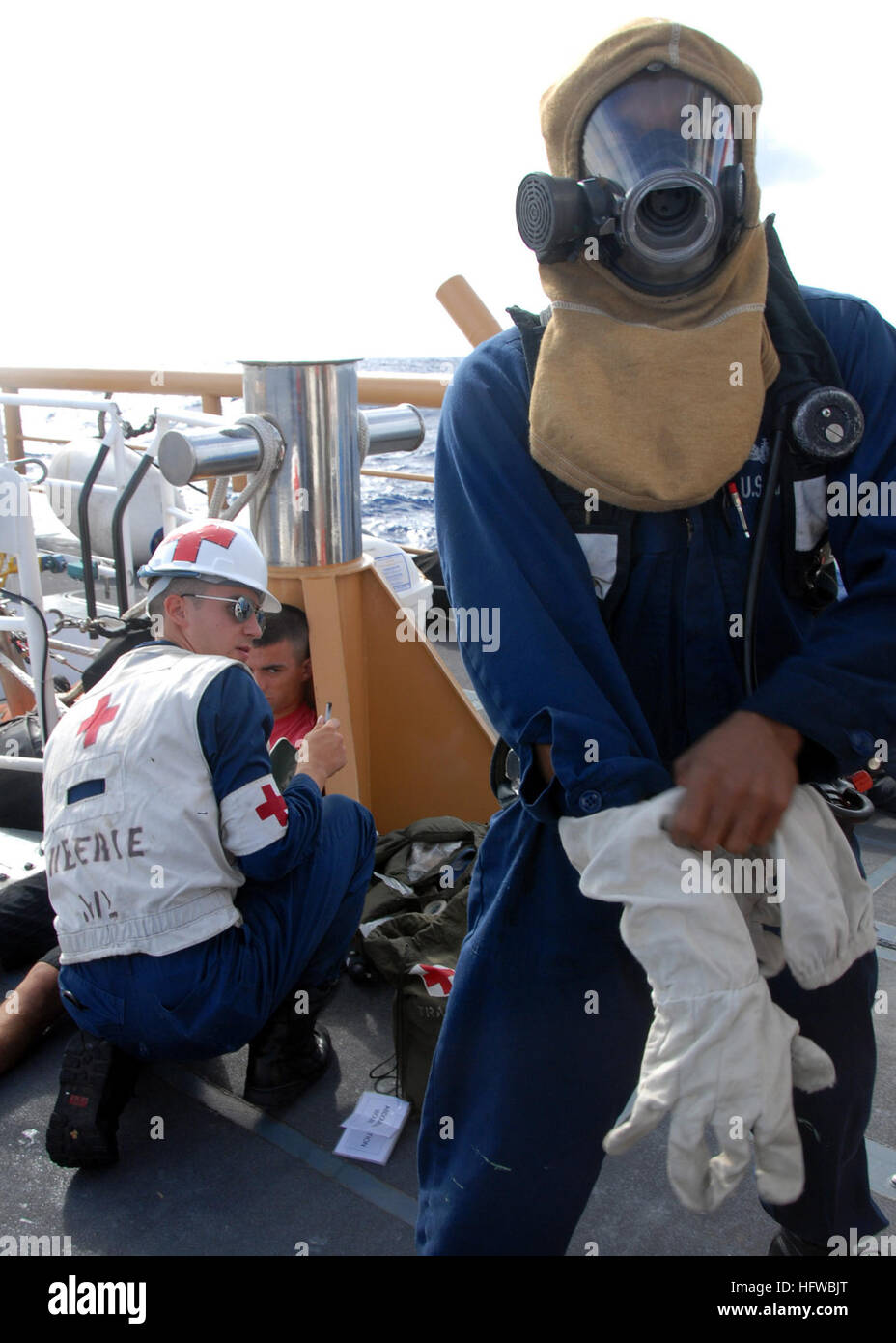 080805-N-9758L-076 OCEANO PACIFICO (Agosto 5, 2008) Danni Controlman 2a classe Tavarish McNair, assegnato all'Ticonderoga-class guidato-missili cruiser USS Lake Erie (CG 70), dons ingranaggio di estinzione mentre Hospital Corpsman 3rd Class Michael Mullin esamina Coast Guard Fireman Logan Schindler per un colpo di calore durante una ricerca trilaterale e esercitazione di soccorso a bordo della U.S. Guardacoste Kittiwake (WPB 87310). Kittiwake servita come una simulazione di distressed nave posizionati a circa 20 miglia ad est di Kauai, Hawaii. L'esercizio è stato trattenuto per migliorare la tri-protezione laterale della cooperazione tra la Marina Foto Stock