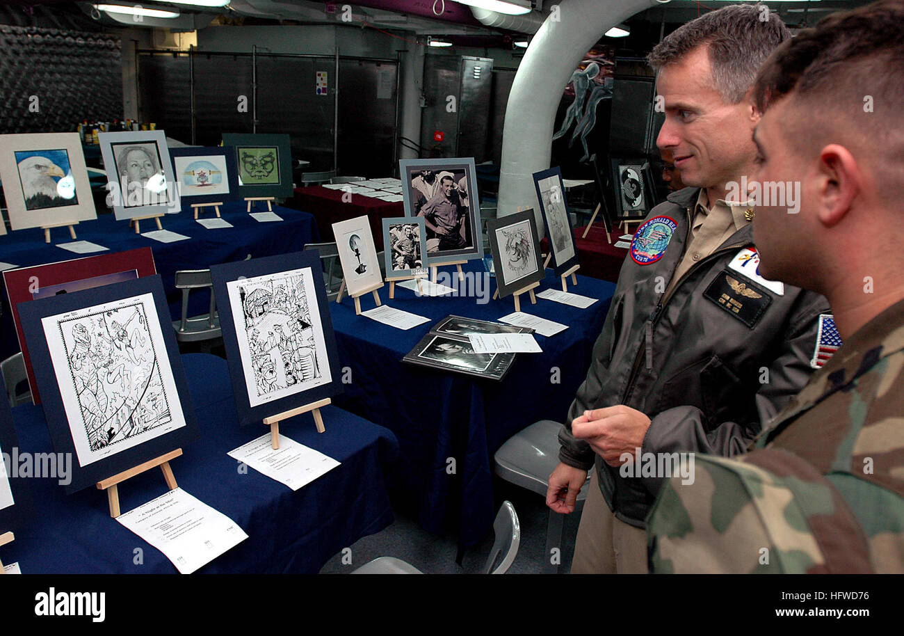 050622-N-5800K-044 Oceano Pacifico (22 giugno 2005) - Magazziniere 2a classe David Hyatt, destro fornisce la USS Ronald Reagan (CVN 76) Senior Medical Officer, la Cmdr. John Burgess, con qualche approfondimento del suo stile fumetto illustrazione durante la nave del primo ÒMetropolitan Art Center Juried Art Show e mostra.Ó la mostra d'arte visualizzato oltre 50 pezzi da più di venti artisti differenti in tutta la nave. La Nimitz classe alimentato nucleare portaerei sta attualmente conducendo di routine le operazioni di carrier. Stati Uniti Navy foto di PhotographerÕs Mate Airman Thomas C. Kuhl Jr. (rilasciato) Navy US 050622-N Foto Stock