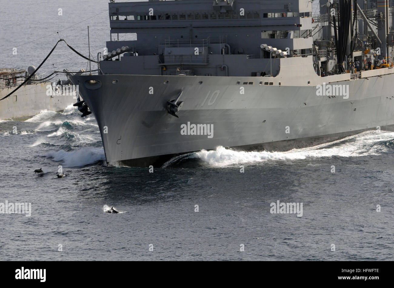 081015-N-3659B-372 Golfo di Oman (ott. 15, 2008) i delfini saltare fuori dall'acqua fuori della prua del militare comando Sealift fast combattere la nave appoggio USNS Ponte (T-AOE 10) durante un rifornimento in mare tra il ponte e il Ticonderoga-class guidato-missili cruiser USS Chancellorsville (CG 62). (U.S. Foto di Marina di Massa lo specialista di comunicazione 2a classe Joseph M. Buliavac/RILASCIATO) Navy US 081015-N-3659B-372 Delfini saltare fuori dall'acqua fuori della prua del militare comando Sealift fast combattere la nave appoggio USNS Ponte (T-AOE 10) durante un rifornimento in mare Foto Stock