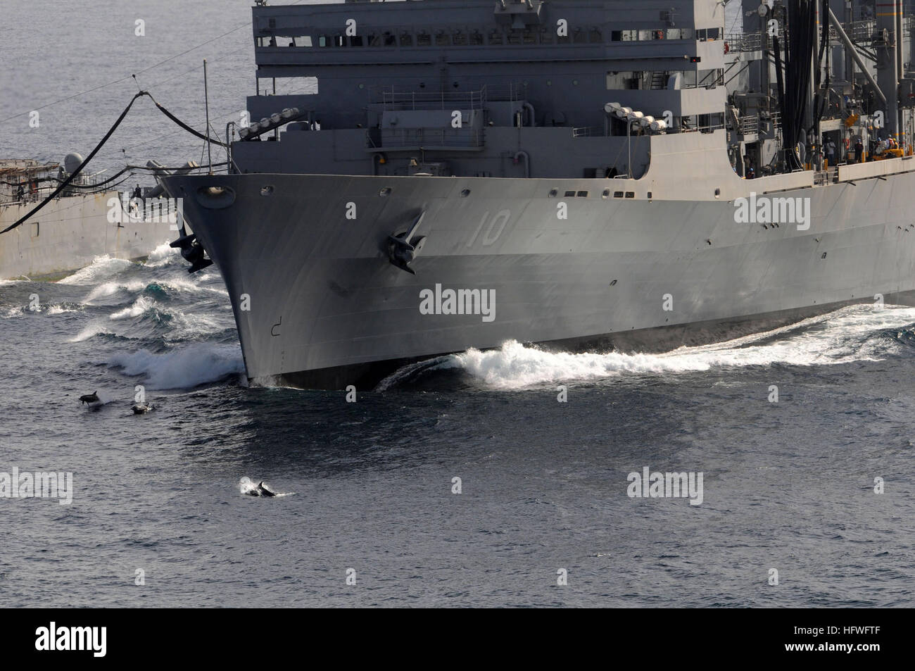 081015-N-3659B-372 Golfo di Oman (ott. 15, 2008) -i delfini scherzosamente saltare fuori dall'acqua fuori la prua del militare Sealift Command (MSC) fast combattere la nave appoggio USNS Ponte (T-AOE 10) durante un rifornimento in mare tra il ponte e il Ticonderoga-class guidato-missili cruiser USS Chancellorsville (CG 62). Le navi di MSC flotta navale forza ausiliaria sono le linee di alimentazione per gli Stati Uniti Navi della Marina Militare in mare. Ronald Reagan è attualmente implementata per la Quinta Flotta/NAVCENT area di responsabilità. Le operazioni in NAVCENT area di operazioni sono incentrate sulla rassicurante partner regionali degli Stati Uniti Foto Stock