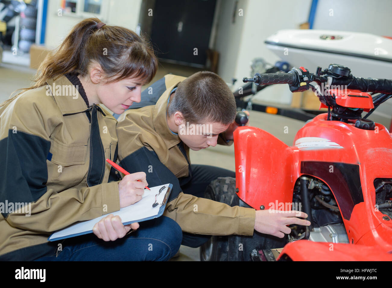 Giovani meccanica esaminando quadbike Foto Stock