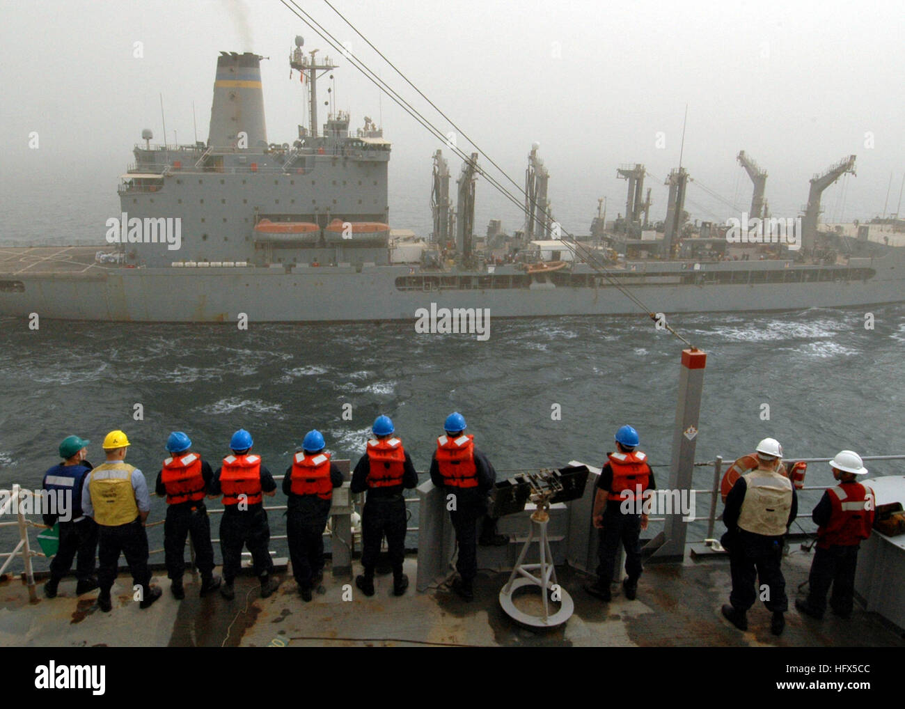 090212-N-9134V-001 Golfo Persico (feb. 12, 2009) i marinai a bordo del dock anfibio sbarco nave USS Carter Hall (LSD 50) guarda come militare comando Sealift flotta oliatore di rifornimento USNS Tippecanoe (T-AO 199) arriva a fianco della nave per un rifornimento in mare durante una tempesta di sabbia. Carter Hall è distribuito come parte dell'Iwo Jima Amphibious pronto Gruppo di supporto le operazioni di sicurezza marittima NEGLI STATI UNITI Quinta Flotta area di responsabilità. (U.S. Foto di Marina di Massa lo specialista di comunicazione 2a classe Flordeliz Valerio/RILASCIATO) Navy US 090212-N-9134V-001 i marinai a bordo del dock anfibio landing s Foto Stock