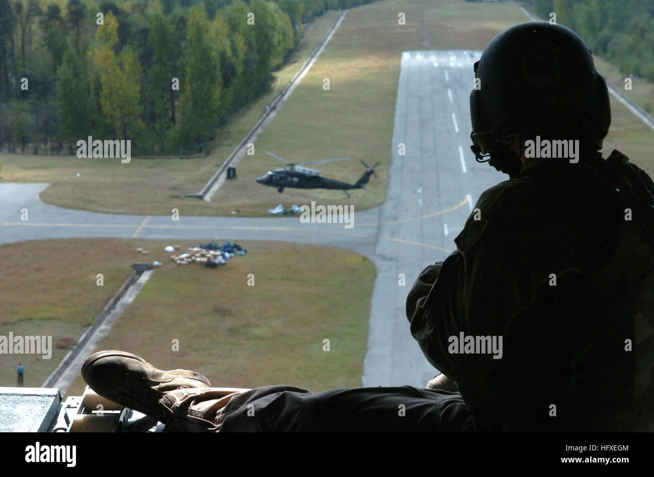 051012-N-8796S-241 Rawalakot, Pakistan (ott. 12, 2005) - STATI UNITI Esercito equipaggio stati si siede nella rampa della CH-47 elicottero Chinook come UH-60 Blackhawk elicottero decolla sotto dopo la caduta di aiuti di emergenza al remoto villaggio pakistano di Rawalakot. Il governo degli Stati Uniti sta partecipando a una multinazionale di assistenza umanitaria e di supporto di piombo di sforzo da parte del governo pakistano per portare aiuto alle vittime del terremoto che ha colpito la regione di Ottobre 8, 2005. Stati Uniti Navy foto di PhotographerÕs Mate 2a classe Timothy Smith (rilasciato) Navy US 051012-N-8796S-241 U.S. Un Foto Stock